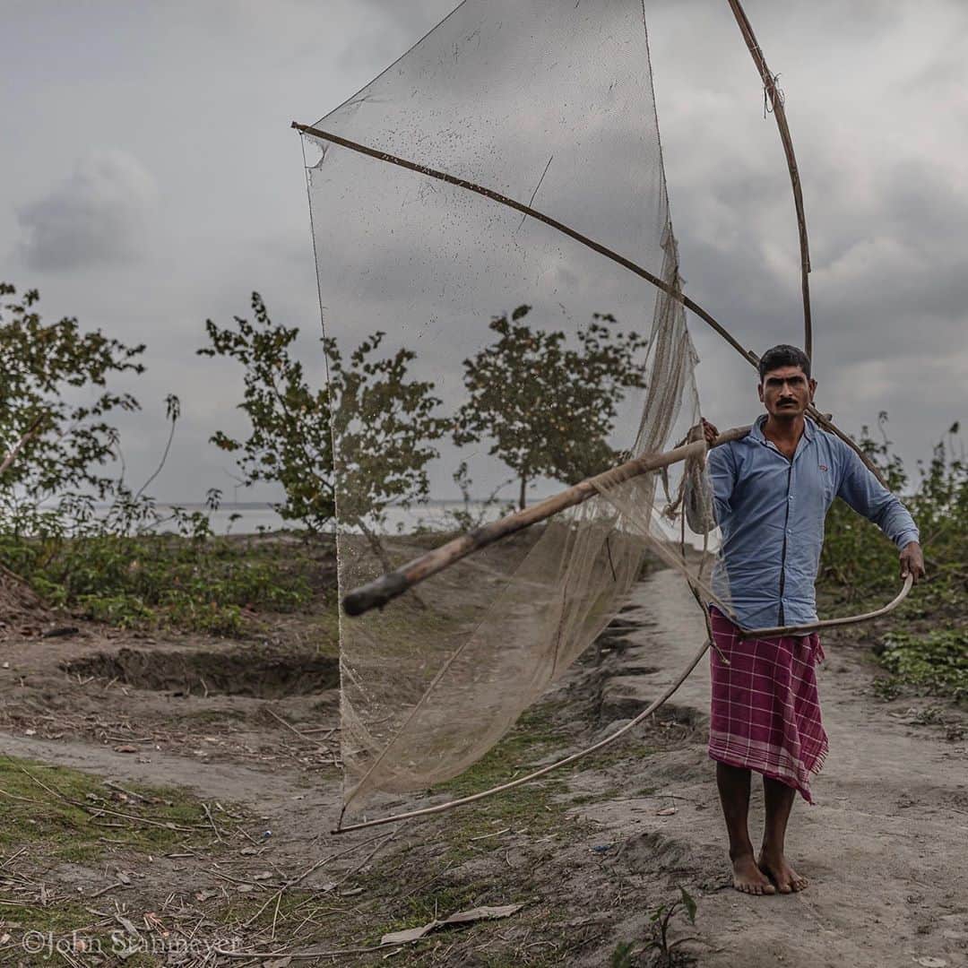 のインスタグラム：「He appeared without notice, walking barefoot carrying a fishing net twice his size, moving briskly along a well-worn footpath that led up from the Brahmaputra river. He briefly stopped asking me to take his picture. Fleeting as our time together was, he thanked me, I thanked him, then before I could ask his name, he was gone. Our impromptu encounter was the only time we met during my three days on Majuli Island in Assam, India. Another person whose name I will unfortunately never know. ⠀⠀⠀⠀⠀⠀⠀ India’s Daunting Challenge: There’s Water Everywhere, And Nowhere - Chapter 8 of the @outofedenwalk, my latest story last months (August 2020) @natgeo magazine. ⠀⠀⠀⠀⠀⠀⠀ #portrait #fisherman #fishnet #brahmaputrariver #brahmaputra #assam #india @natgeo @outofedenwalk #walkingindia #edenwalk」