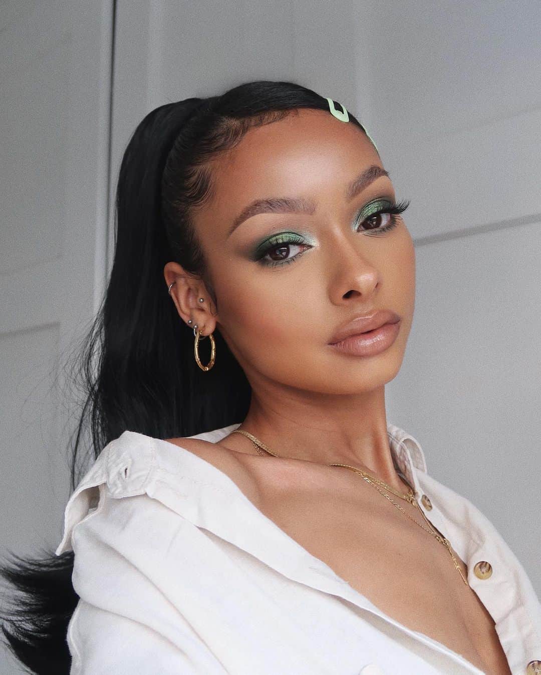 ジェイデ・ピアスのインスタグラム：「A little green moment 💚 BROWS: • @gsunique for brow lamination • @benefitcosmeticsuk precisely my brow pencil, brow zings and gimme brow (all shade 4) EYES: • @meltcosmetics smoke sessions eyeshadow palette • @lillylashes in the style “diamonds” • @narsissist climax extreme mascara FACE: • @esteelauderuk double wear foundation (shade 4N2) • @lauramercier flawless fusion concealer (shade 4N) • @toofaced both this way multi use sculpting concealer (shade warm beige. I use this to brighten areas) • @lauramercier loose setting powder (shade translucent honey) • @fentybeauty match stix (shade truffle) • @fentybeauty sun stalk’r bronzer (shade caramel cutie) • @nudestix nudies matte blush (shade nude peach) • @hudabeauty all over highlighting powder (shade flora) LIPS: • @ctilburymakeup pillow talk lip cheat (shade 3 intense) • @fentybeauty slip shine sheer shiny lipstick (shade glazed) • @fentybeauty gloss bomb (shade glass slipper)  ACCESSORIES: • Ponytail is from @lullabellzuk (mini grande 18” in natural black) • Gold hoops and short gold necklace are from @daisy_jewellery • Longer gold necklace I’ve had since the age of 13 lmao • hair clips are from @bershka」