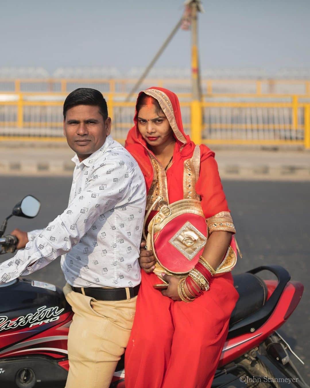 ジョン・スタンメイヤーさんのインスタグラム写真 - (ジョン・スタンメイヤーInstagram)「I met so many kind people in India. Three of the many I met on motorcycles were Priyanka Devi and her partner, Roshanlan, in Prayagraj (Allahabad). When I was on the unimaginative named New Yamuna Bridge (it happens to cross the Yamuna River, and it’s new...), they stopped to say hello. One of countless random hellos to ask where I was from and to please take their picture, and a selfie. Another encounter was Bijul. A sweet, bright-eyed girl was sitting on the back of her father’s motorcycle while I was standing in a burning rice field after harvesting in Punjab. Like Priyanka Devi, she too was dressed in brightly colored clothing, and like Roshanlan, Bijul’s father wanted to say hello and to take their picture. Usually, when I make such portraits, I do out of courtesy to those asking, almost unconsciously. I was surprised days later when editing...there was something beautiful about these two pretenseless portraits. Thankful, both arriving into my life on motorcycles.  ⠀⠀⠀⠀⠀⠀⠀ India’s Daunting Challenge: There’s Water Everywhere, And Nowhere - Chapter 8 of the @outofedenwalk, my latest story last months (August 2020) @natgeo magazine. ⠀⠀⠀⠀⠀⠀⠀ #portrait #partners #motorcycle #yamunariver #newyamunabridge, #prayagraj #allahabad #uttarapradesh #punjab #child #india @natgeo @outofedenwalk #walkingindia #edenwalk」9月29日 13時29分 - johnstanmeyer