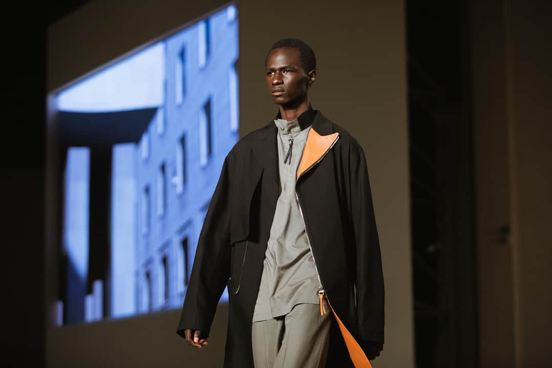 サルヴァトーレ・フェラガモのインスタグラム：「A thread of sustainable consciousness runs through passages of both menswear and womenswear in the Salvatore Ferragamo Spring/Summer 2021 collection. Featured here, a black overcoat with a contrast lapel made from repurposed leather scraps, in a Hitchcock Tan colour, aptly named after the director’s seminal works that inspired the collection. #FerragamoSS21」