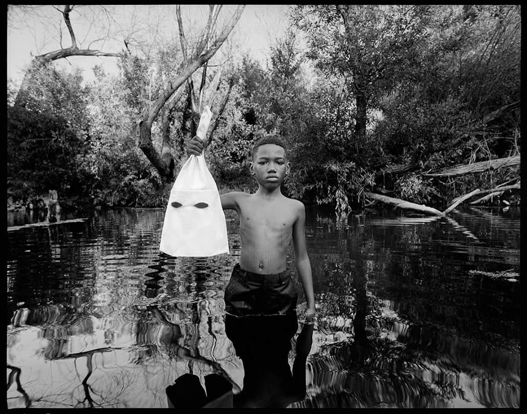 タイラー・シールズのインスタグラム：「THE KID  This photograph is the melding of strength and sorrow. Making clear the tension between youth and history in today’s modern age. My series Historical Fiction was about making images that go beyond me and beyond the photograph, images that make a statement. Six years ago I took an image entitled “Lynching” of a black man hanging a kkk member. At the time I had no idea how impactful the image would be. Six years later we seem to be in the very same place with a new generation of eyes watching and longing for change. “The kid” was shot in the exact same location as the “Lynching” photograph. Both capturing the same feel though taken years apart they seemingly go together as a diptyque separated only by time. This is an important piece to me as we are called to reconnect to our humanity we must all connect to our innocence and find the kid inside of ourselves. Revisiting this world in our current times was painful and beautiful all at once just like the photograph. “The kid” was beautifully played by Malik and I want to thank him and his family for trusting in my image and exhibiting such strength and vulnerability. What does this image represent to you?」