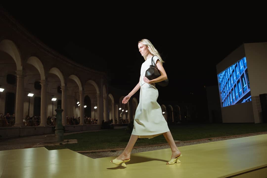 サルヴァトーレ・フェラガモのインスタグラム：「Plush leather fabrications designed for lightness, flexibility and strength appear in the Salvatore Ferragamo Spring/Summer 2021 collection, as seen on Kiki Willems who opened the runway show at the historic Rotonda della Besana, with a sleeveless below-the-knee white Nappa dress. #FerragamoSS21」