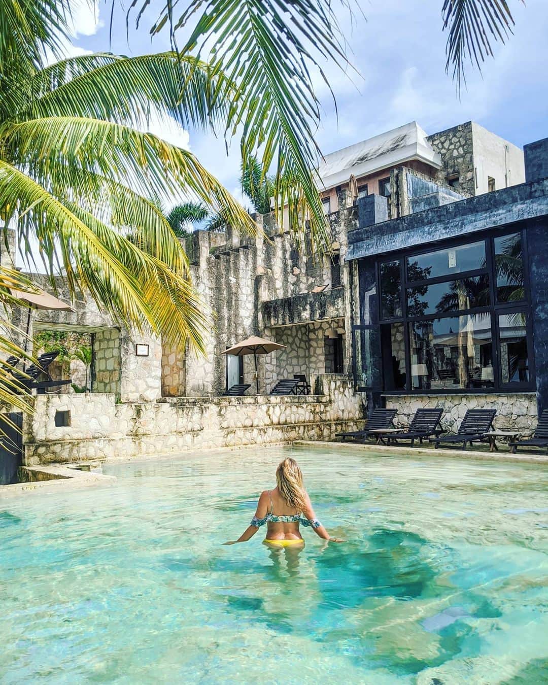 アリサ・ラモスのインスタグラム：「Add this hidden gem that's often skipped to your Riviera Maya bucketlist: COBÁ!! . Located in between trendy Tulum and World Wonder Chichén Itzá, the ancient Mayan city of Cobá sits on a massive area of jungle with ruins and a pyramid that's actually the tallest one in the Yucatan peninsula! It was also said this city was run by women! . If you've ever visited Mayan, Aztec, or Incan ruins, you'll know that there's a strong energy feeling around them. I definitely felt that here! And also moments where I felt like I was transported to another time and place! . Oh but about the photos! This is actually a boutique hotel, completely hidden amongst the dirt roads and small local houses with chickens in the yards. I only heard about it because of a friend back in LA! . I wanted to mention it because here I felt transported to another time as well, like when travelers would wear all khaki and have heavy trunks as luggage (that's how the inside is decorated).  . Not only does the exterior look like it's built on Mayan ruins, but even the pool floor is constructed to look like a cenote! Inside is a perfumería where you can make your own scent, and there's also a cute little restaurant you can have lunch at after exploring the ruins and cenotes nearby. . Will have the info for it in my Cobá blog post/itinerary! . What/where is the most unique hotel you've ever seen?? . 👙#MyLifesaSummerMovie ("Amazon Jungle" with reversible bottoms) . . . #coba #rivieramaya #quintanaroo #coquicoquicoba #mexico #mylifesatravelmovie」