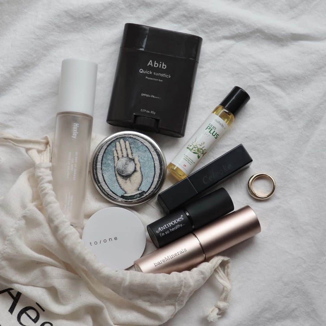 のインスタグラム：「. . 私のポーチの中身🌵 . . @bareminerals_jp のファンデはスティックタイプで持ち歩きしやすいのと、重ね塗りしても粉っぽくならないところがお気に入り👌 . . リップは @antipodesskincare の03と @celvoke.jp のマスタードを重ね塗り💄 . . @nahrin_japan のハーブオイルはリフレッシュしたい時に。 こめかみ、首筋、肩にコロコロするとスーッとしてやみつき！頭痛も和らぐ気がする！ . . @o_skin_hair のバームはヘアワックス、ハンドクリーム、リップ兼用 柑橘系の香り🍋 缶が薄くて嵩張らないのも◎ . . @toonecosmetics のチークはミラー代わり。 . . @huxley_japan のオイルミストは乾燥が気になった時に顔や髪にスプレー。 香りもいい🌿 . . @abib.japan の日焼け止めスティックは手が汚れず塗り直しができるところと、無色で服が汚れない所も🙆🏻‍♀️ . . . . #ポーチの中身 #inmybag #bareminerals #antipodes #celvoke #nalin #oskincare #huxley #abib #cosmetics #organiccosmetics #kuronecosme」