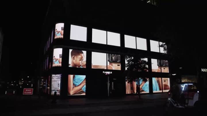のインスタグラム：「#MelekoMokgosi: Coinciding with "Democratic Intuition" at Gagosian, Britannia Street, London, is an exciting collaboration between Meleko Mokgosi, Gagosian, and the urban art initiative W1 Curates on an outdoor digital installation of monumental scale. The project comprises an algorithmic sequence of image fragments and text panels from Mokgosi’s narrative paintings, digitally adapted to the full scale of the Flannels flagship store at 161–167 Oxford Street in Soho. The sequence will play in a ten-minute loop across the three-story LED facade of the building twenty-four hours a day, through October 18. __________ #Gagosian @w1curates @flannelsman Meleko Mokgosi's work installed at Flannels, London © Meleko Mokgosi. Video and photos: courtesy W1 Curates」