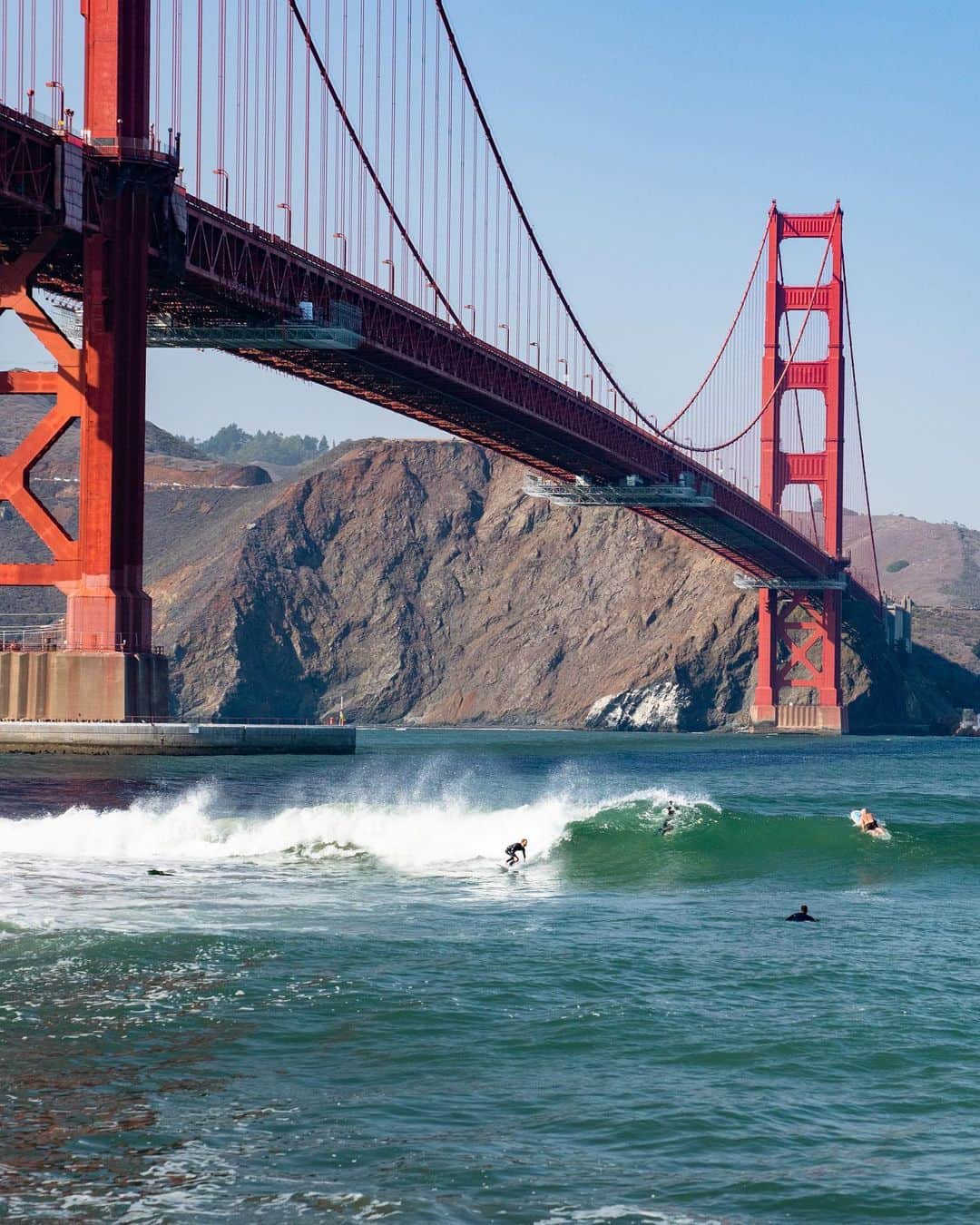 Travis Burkeのインスタグラム：「I’m finally back on the road and what a cool first stop, surfing under the Golden Gate Bridge in San Francisco!  It feels so good to be getting back in my flow state, traveling and chasing new adventures.  Disclaimer- This place is not for beginners, from the hidden underwater boulders, shark attacks, and strong currents, there is a lot to be on the lookout for. And remember to always respect the locals!  Huge thanks to @gypsealaysea for documenting the day before we continued heading north.」