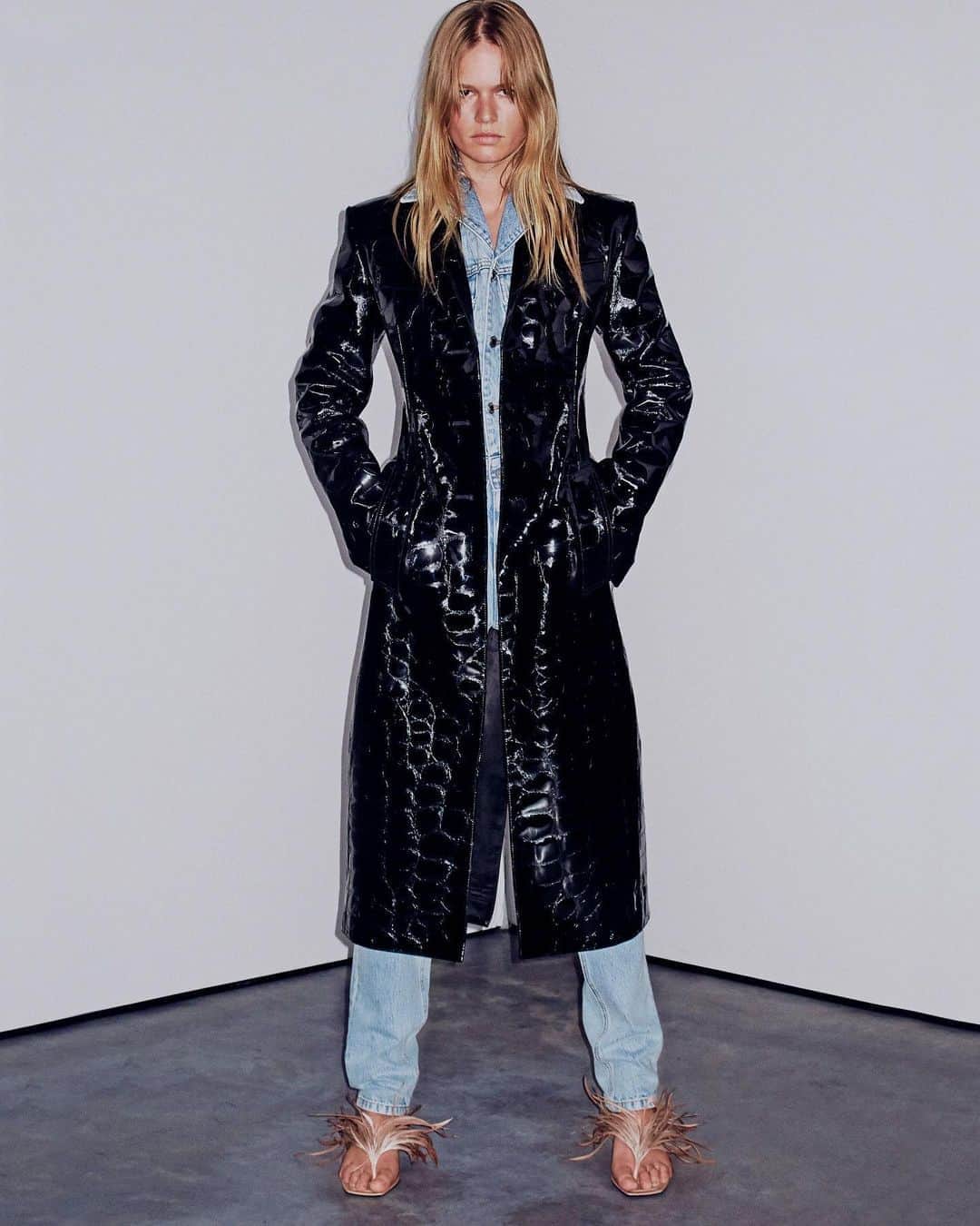 アレキサンダー・ワンのインスタグラム：「emBOSSed. -  FITTED SINGLE BREASTED COAT IN CROC EMBOSSED PATENT LEATHER.  CROPPED LAPEL COLLARED DENIM TRUCKER JACKET.  HIGH WAIST SLIM JEAN IN PEBBLED BLEACH WASH WITH STACKED INSEAM.  IVY THONG SANDAL WITH HAND-PLACED GOOSE FEATHERS.  STRONG SUIT SHOT TO SHOP BY STEVEN KLEIN.」