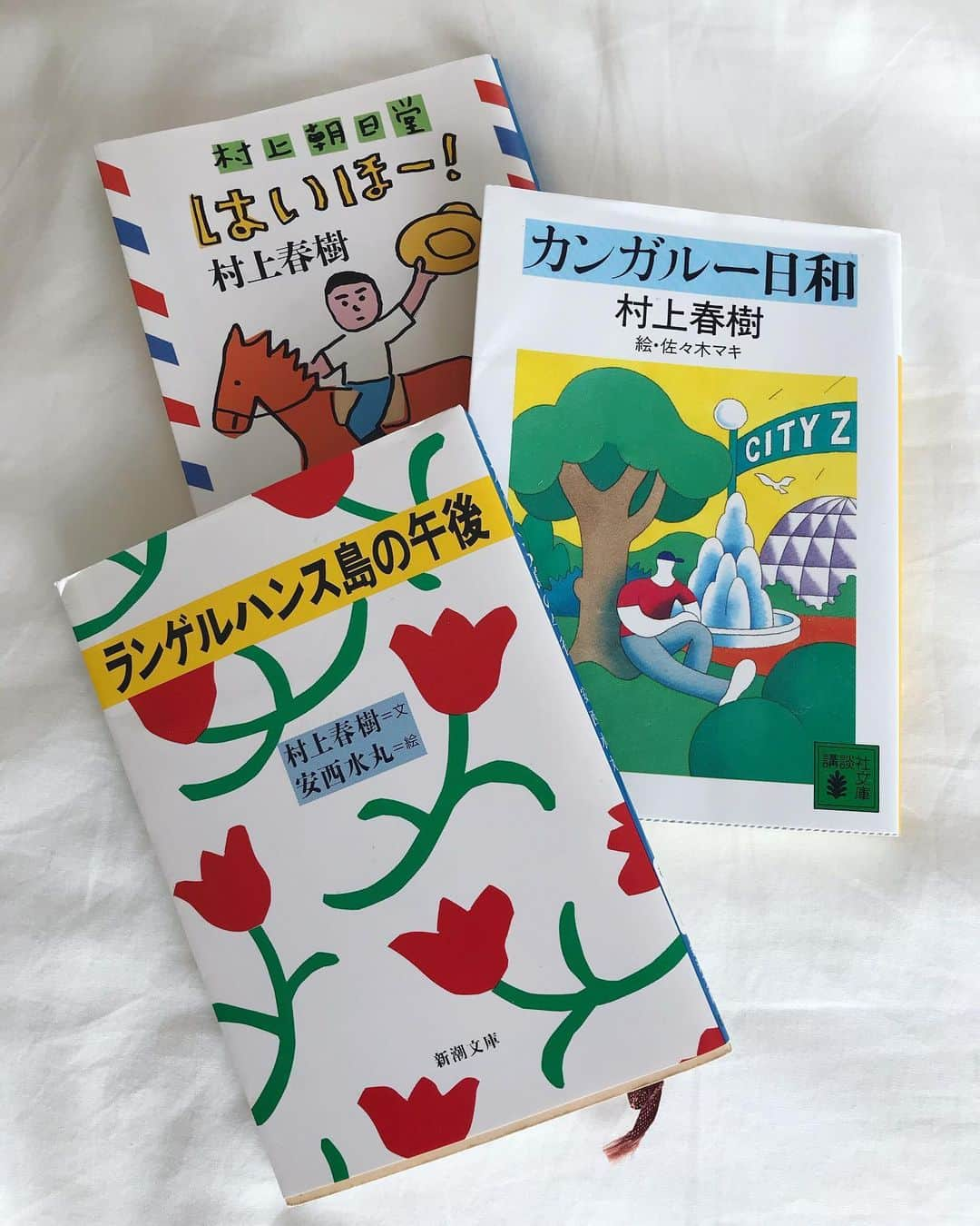 坂詰美紗子のインスタグラム：「「4月のある晴れた朝に100パーセントの女の子に出会うことについて」が好きだって事、前にも書いたっけなぁ。忘れちゃった。 ランゲルハンス島の午後は水丸先生の赤いお花が可愛いくて好き。 本棚から村上春樹先生の作品を引っ張り出してたワケは、今回のエッセイのタイトルが「なんでちゃんと村上春樹」だから。 昔のことを思い出して書いていると、やっぱり気分は浦島美紗子なのである。←前回に続き。w ・ ・ ・ #エッセイ #村上春樹を読むようになったわけ #ACTIS #フリーペーパー #全国で配布中 #webでも読めます #なんでなんで #今回はじめて楽曲についても触れてみました」