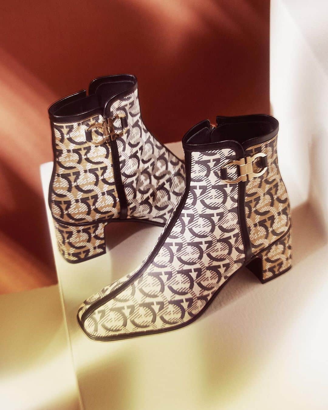 サルヴァトーレ・フェラガモのインスタグラム：「In a series of visually compelling scenes, the iconic motif of the gancini reigns supreme over the design canvas of expertly crafted ankle-length boots in jacquard. Swipe right to see the latest iterations of the Trifolio and Boxyz bags with signature gancini shoulder straps. #FerragamoAW20」
