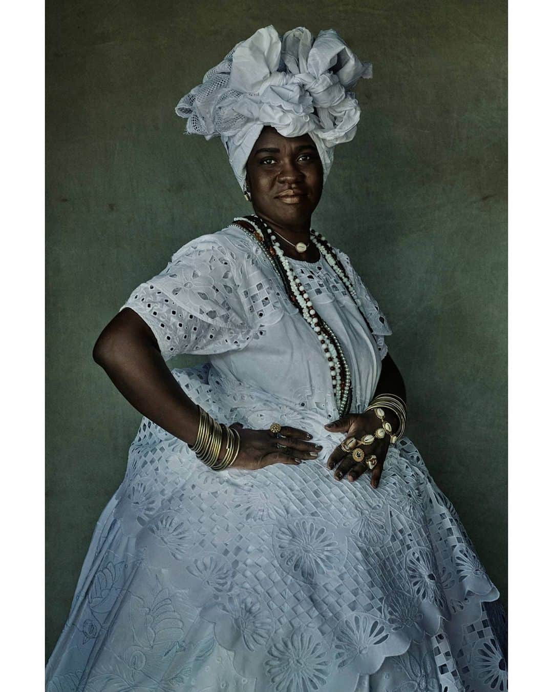 マリオ・テスティーノのインスタグラム：「I have always reacted to the volume created by fabric as there is something regal about it. The traditional dresses of the Baianas, their full skirts and their incredible turbans, make them look and move like queens. The fabric of the dresses, the colours, and the jewels they use as part of their heritage and identity only multiply this feeling. ⁣ It is amazing to see how Afro-Brazilian traditions not only survive but thrive to this day, and the influence they’ve had in the beauty you can find in everyday life in Bahia. ⁣ _⁣ Há algo de majestoso no volume criado por tecidos, e eu sempre fui atraido por esta suntuosidade.⁣ As baianas com seus vestidos tradicionais, suas saias rodadas e seus incríveis turbantes fazem com que elas se movam de uma maneira majestosa, como rainhas.⁣ O tecido dos vestidos, as cores e as jóias que elas usam fazem parte da identidade e riqueza cultural da baiana e fortalecem esse sentimento de estar diante de realeza.⁣ É incrível ver como as tradições afro-brasileiras não apenas sobrevivem, mas prosperam nos dias de hoje, influenciando a beleza encontrada na vida cotidiana da Bahia. ⁣ ⁣ #ABeautifulWorl #Brazil #Baianas #MarioTestino #CandeSalles」