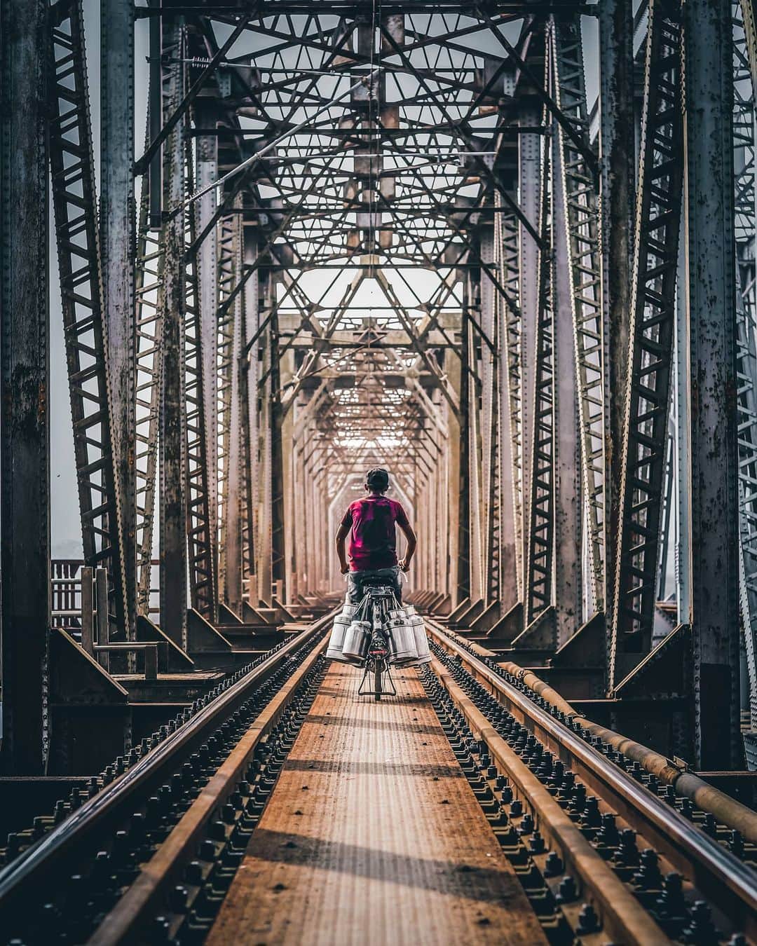 Canon Asiaさんのインスタグラム写真 - (Canon AsiaInstagram)「Here's what we call an excellent portrayal of architectural framing by @__swap__! 😍  The repetitive pattern on the trestle bridge along with the railway track gives this shot a centralised and well-balanced composition. Additionally, the natural vignette effect from the backlight and monotonous support structure lead the viewer to the main subject seamlessly.  The railway bridge crossing is a must for many on their way to wok daily, and this photo captures determination despite a journey of hardship.  📷 Image by @__swap__ using the Canon EOS 77D • EF50mm f/1.8 STM • f/2.8 • ISO 100 • 1/640s • 50mm  Got a shot with a story to tell? Tag us #canonasia or share them on My Canon Story, link in bio!  #canonasia #photography #explore #composition #colours #canon #symmetry #lens #inspiration #train #railway #subject #architecture #architecturephotography #colours #leadinglines #dombivli」10月28日 17時22分 - canonasia