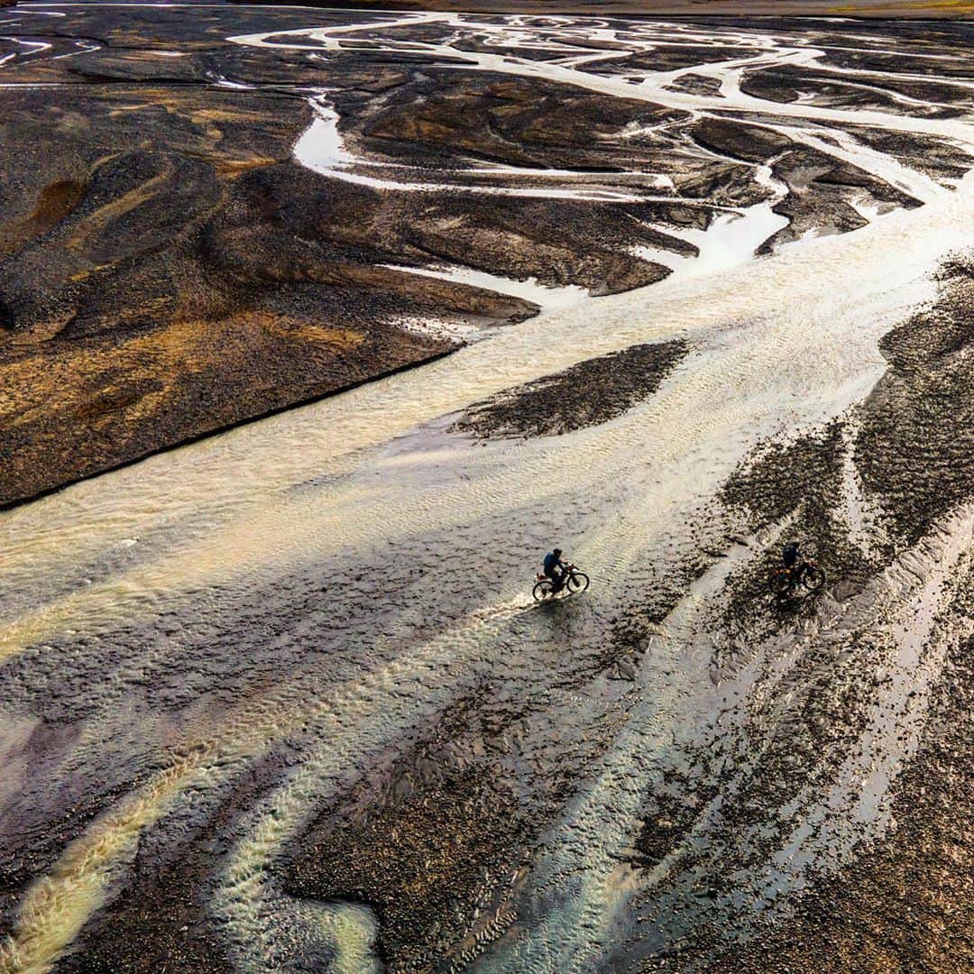 クリス・バーカードのインスタグラム：「Been ruminating lately on these remote & wild stretches of river we had to cross on bike ( mostly on foot) while traversing the deep and empty expanse of Iceland’s interior. For a country that I have always associated with water and lots of it... I was blown away by much of a desert it really is. Huge expanses of moisture-less terrain would be between us and our next drink of water. These places force you at times to appreciate the most simple of necessities. Those moments bring us back to a very raw & primal way of operating. It hones the senses & strips away a lot of unnecessary B.S.  from your everyday existence. Like I said above.. ruminating .. mostly on the WHY hard things are important for growth.  @emilybatty1 @ericbatty @adammorka @jordanrosenphotography  @zippspeed @srammtb @iamspecialized_adv @schwalbetires @wahoofitnessofficial」