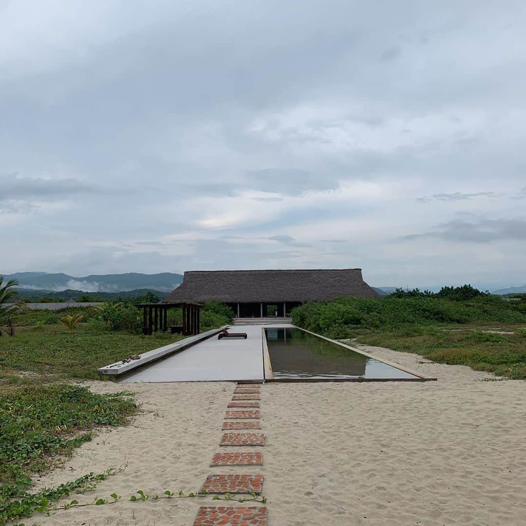 トームさんのインスタグラム写真 - (トームInstagram)「Tadao Ando's #CasaWabi is an artist's retreat that stretches along the Mexican coast  A 312-metre-long concrete wall provides the framework for this house and art centre designed by Japanese architect #TadaoAndo for a picturesque site on the Mexican seafront. .  The building provides a home for the Casa Wabi Foundation, an arts charity established by Mexican artist Bosco Sodi and directed by Patricia Martin, best known as the curator of Latin America's largest private art collection, the Colección Júmex. .  The plan is laid out like a giant compass. The long concrete wall runs west to east, following the coastline, to create a series of different rooms and zones.  The north-south axis is provided by an approach road, as well as a long narrow terrace and swimming pool that extend out towards the water's edge. . "The project site is situated directly facing the South Pacific Ocean, sharing 550 metres of coastline with only the breathtaking beach," explained Ando, who also recently completed a house in Mexico's Sierra Las Mitras mountains.  "With such a generous length of site, I have created a single concrete wall of 312 metres long by 3.6 metres high," he said.  "The wall creates horizontal separation between public programmes on the north side and private programmes on the south side." .  "The wall also generates the main circulation path cutting across every programme, serving as a dual interior and exterior wall," he added. "Rich red and orange sunset is to be reflected on the concrete surface." . @casawabi @dezeen」10月29日 5時26分 - tomenyc