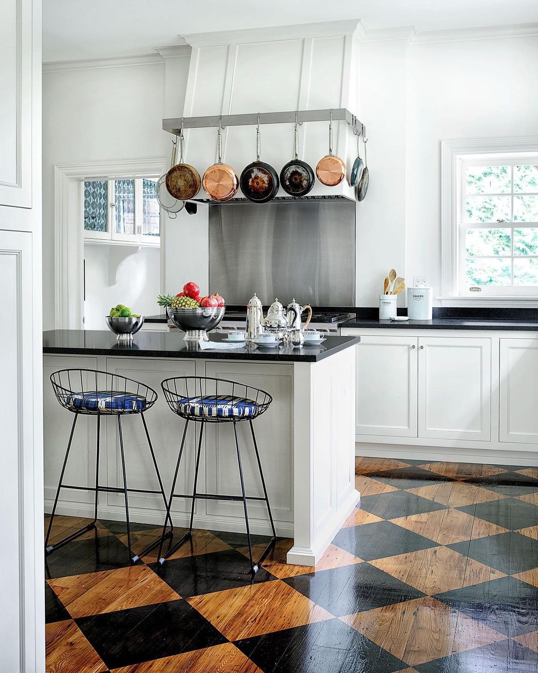 ELLE DECORさんのインスタグラム写真 - (ELLE DECORInstagram)「While most of the spaces in this Pittsburgh family home—designed by Janine Carendi MacMurray of @areainteriordesign—are richly layered, the kitchen is much more clean-lined. A vintage checkerboard pattern lends a graphic, modern quality to the floor, while the white walls and cabinets offer balance. Working with the architect Liza Cruze, MacMurray sketched a pot rack and hood over the stove that elongates the space. The kitchen countertop is from a local quarry, the cabinetry is custom, and the cabinet hardware is from @rejuvenation; the range and vent hood are by @subzeroandwolf, and the hood cover is custom. The barstools are upholstered in a @schumacher1889 fabric, and the floor was painted by David A. Wilson of Masterpiece Painting. Click the link in bio for the full tour, as seen in our November 2020 issue. Written by Stephen Heyman; produced by @cynthiaefrank; photography by @simonuptonphotos.」10月30日 7時55分 - elledecor