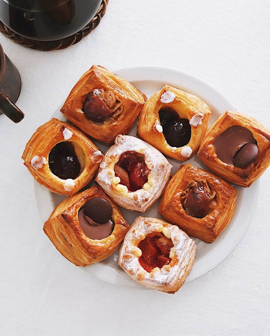 樋口正樹さんのインスタグラム写真 - (樋口正樹Instagram)「Danish Pastry . 今日のおやつヒュッゲは 甘くちいさなデニッシュ、 淹れたてのコーヒー＆猫。 . アンデルセンのちいさな TAKデニッシュは４種で チェリー、ルバーブ＆苺、 チョコ、マロンがあって、 わたしはチェリーが好き、 秋なのでマロンも好きで、 結局全部を食べてしまう。 . ちなみに、 デニッシュ生地は３２層、 ４個を重ねると１２８層。 . ちなみに、 開催中のアンデルセンの デンマーク・フェアより デニッシュペストリーが リニューアルしてますよ。 @andersen_official_jp . さらにちなみに、 "TAK"は "タック"と読み、 デンマーク語で、意味は "ありがとう"なのですー。 人気のTAKデニッシュは 創業７０周年を記念して 感謝の気持ちを込め開発。 ちょっとした差し入れに 嬉しいデニッシュですね。 . . #ありがとう #アンデルセン #パン #TAKデニッシュ #デニッシュ #デニッシュペストリー #ベーカリー #アンデルセンのパン #ヒュッゲ #デンマーク #デンマークフェア #パンのある暮らし #パンのある生活 #パンスタグラム #パン大好き #andersen #bread #bakery #hygge #copenhagen #bageri #denmark #🇩🇰 #Danishpastry」10月8日 16時06分 - higuccini