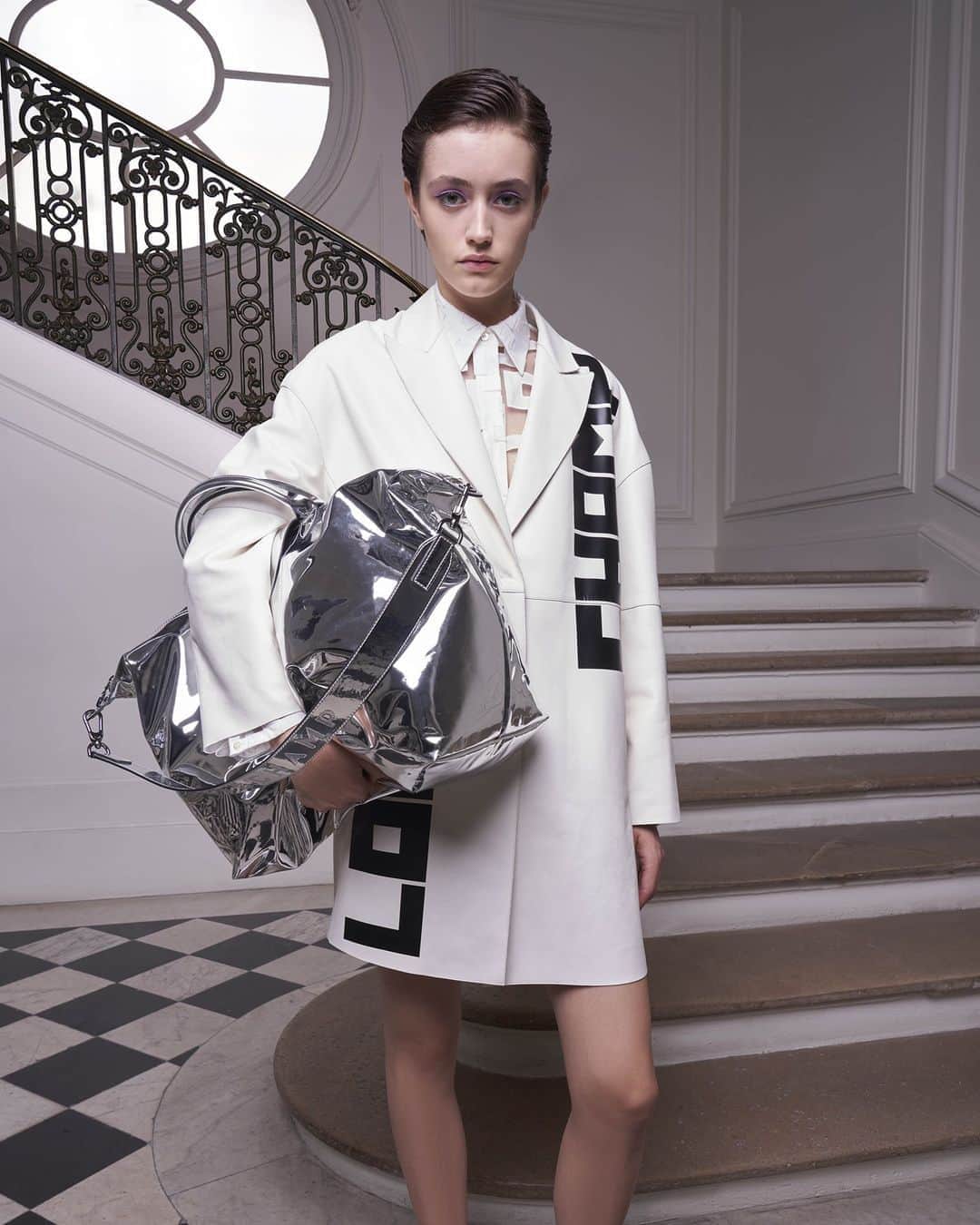 のインスタグラム：「“She liked to be prepared. So she carried her life around in a bag... but somehow made it look easy.” Leather Coat, Cotton Organza Shirt, Freeminder Sneakers, and the Large Metallic Le Pliage Bag, all from our #LongchampSS21 ollection.  #LongchampLePliage #LongchampRTW #Longchamp」