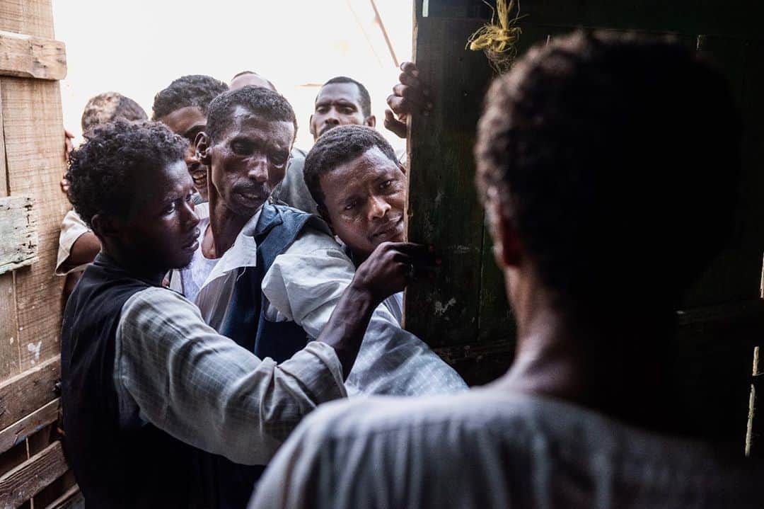 National Geographic Creativeさんのインスタグラム写真 - (National Geographic CreativeInstagram)「Photo by @nicholesobecki / Men jostle to buy bread outside a bakery in Sudan’s Suakin town, in the country’s eastern Red Sea region. Among the most pressing of the challenges Sudan faces today is its economy, battered by decades of mismanagement and corruption. The cost of some staple foods like bread and sugar have doubled over the past few weeks, driving inflation to a record high of 167%. Seemingly endless bread and fuel lines are a common site across the country, and on September 10 Sudan declared an economic state of emergency. The country’s one-year-old transitional government has been battling multiple crises in 2020, including the economy, the COVID-19 pandemic and massive flooding. #sudan #history #economy」10月8日 20時59分 - natgeointhefield