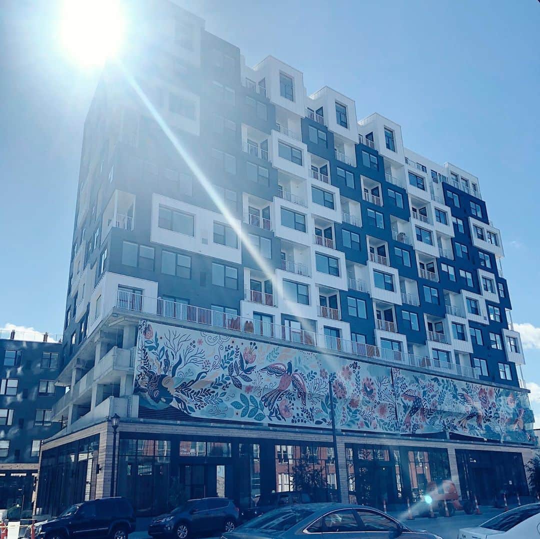 Dinara Mirtalipovaさんのインスタグラム写真 - (Dinara MirtalipovaInstagram)「Today was an exciting day to witness the process of installation of my long awaited mural! I designed it for Cleveland’s new residential complex called @livechurchandstate that is located right in the intersection of the historical Church Ave and old State st ( now West 29th). It’s my first public art project and I was so excited and optimistic about it and yet so worried and obsessed over every little detail. We arrived around noon and the crew was already in the process of hanging the top side. It’s printed on a mash breathable material and is expected to last a few years. There’s a total of 8 façades and they will be hung in the next few days. I’ll definitely stop by to see it all installed and will give you a tour.  👉P.s. head over to my IGTV there’s a longer video of us being excited 😊🌿 #mirdinaraxchurchstate #thisiscle  @thisiscle」10月9日 8時53分 - mirdinara