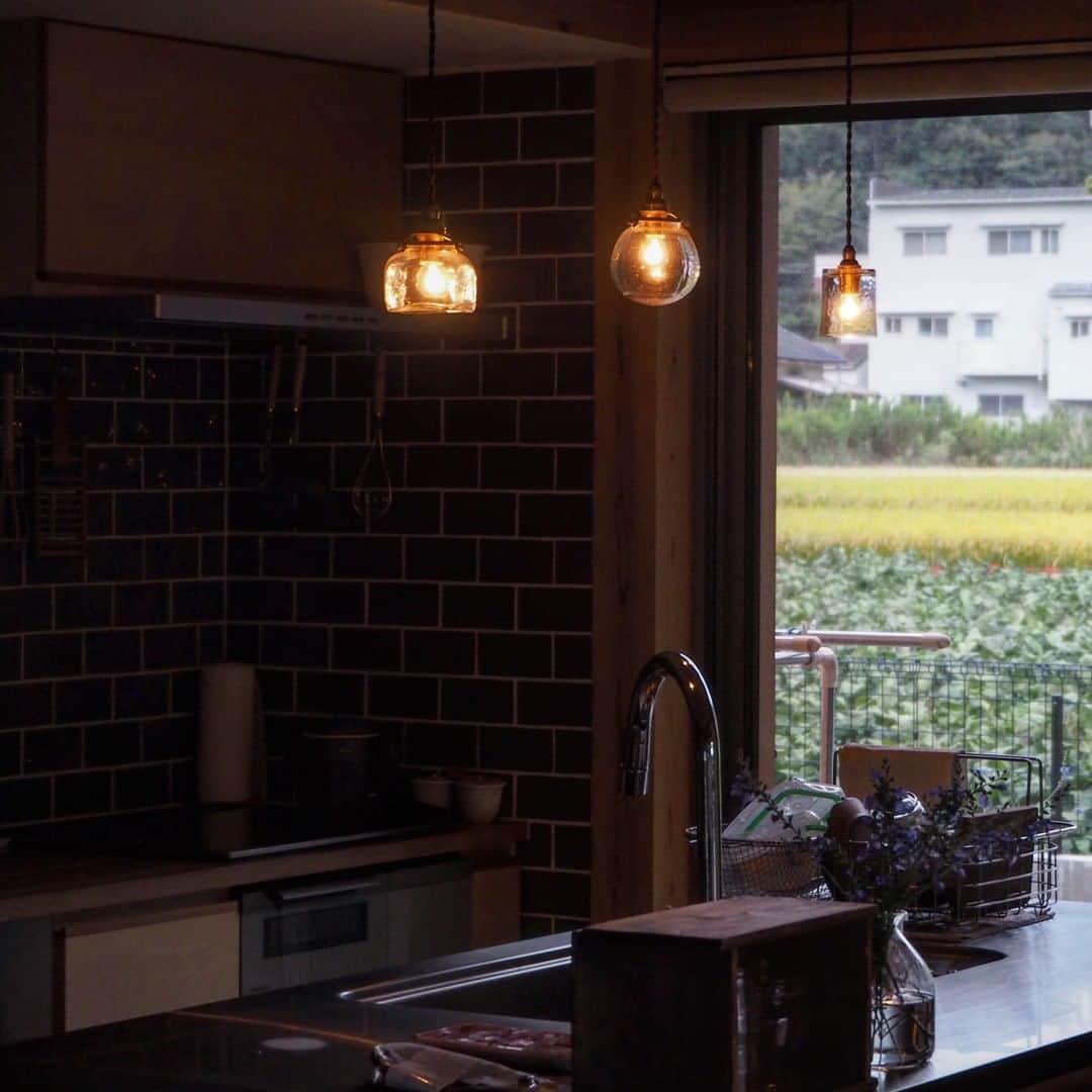 ムクリ［mukuri］さんのインスタグラム写真 - (ムクリ［mukuri］Instagram)「目を惹くキッチンは我が家の顔〜田舎町に溶けこむ風情のあるおうち（ayumi2519さん）  ブラウンのタイルと無垢材が パッと目を惹く温かみのある造作キッチン。  キッチンは家の中心的存在であり、 ayumiさんが一番好きな場所なんだそう。  毎日使うのはもちろん、 夢である石けん教室を開くことを思い描いたキッチンには ayumiさんの特別な思いが詰まっていました。  家の中で目を惹く存在にするにはどうしたらいいか、こだわり抜いて考えられた自分だけの造作キッチンは思い入れもひとしお。  息子さんとのほっこりするエピソードやアイランドキッチンの使い勝手についてもお話してくださっています。  ayumiさんのキッチンに込めた思い、 どうぞご覧ください♩  @ayumi2519 さん、ありがとうございました！ （編集:maki）  --------------------------------- ●キッチンシンク側 ・幅180×奥行き90×高さ85（センチ）  ●背面キッチン ・幅270×奥行き64×高さ86（センチ） ・天板材質：不明/鏡面塗装仕上げ  ●背面壁 ・タイル：リクシル/型番不明 ・飾り棚幅180×奥行き25.5（センチ） ・棚の間隔：25.5センチ ---------------------------------  ▶詳細はプロフィールのURLよりご覧ください プロフィールはこちらから @mukuri_official ・  #キッチンインテリア#造作キッチン#キッチン#キッチンタイル#キッチン収納 #アイランドキッチン#木の家#マイホーム#マイホーム計画#無垢材の床 #自然素材の家#ダイニングテーブ#古道具#古道具のある暮らし #アンティーク家具 #アンティークのある暮らし#暮らし#暮らしを楽しむ #暮らしの記録 #暮らしを整える #暮らしの道具 #日々の暮らし#緑のある暮らし #ナチュラルインテリア#北欧ナチュラル#くらしの編集#ムクリ」10月9日 21時05分 - mukuri_official