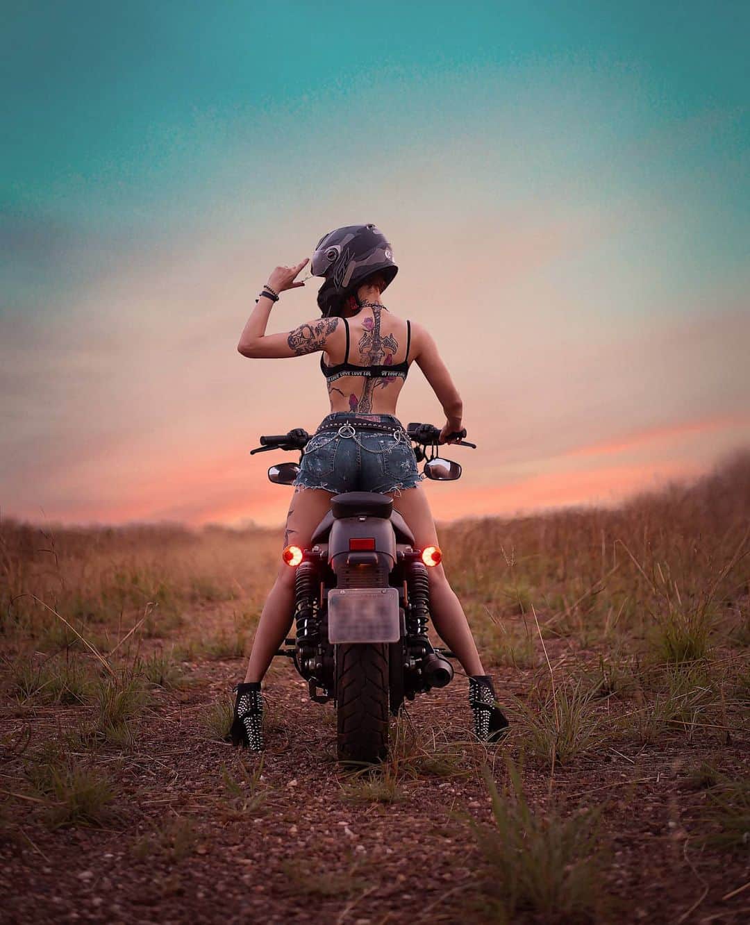 Anna Vargasのインスタグラム：「Friday is my second favorite F word... . The first one is Freedom, you nasty people! 😏🦅 . Here's a "from behind" photo to those of you who ask me to show some more of the back tattoo. It is a valkyrie sword, full of meaningful symbols that I like. I love the symbology of roses too, in addition to their undeniable prettiness. 💁🏻‍♀️🥀 . PS.: The picture looks great an all (@_leonardoribeirooo 's doing, btw) but there was no way my hair would fit into the helmet. I could never actually ride like this! 😂 . . . . . . #freedom #slowride #harley #harleydavidson #sunset #girlsandmotorcycles #motorcycle #hittheroad #tattoo #tattooedgirls #nature」