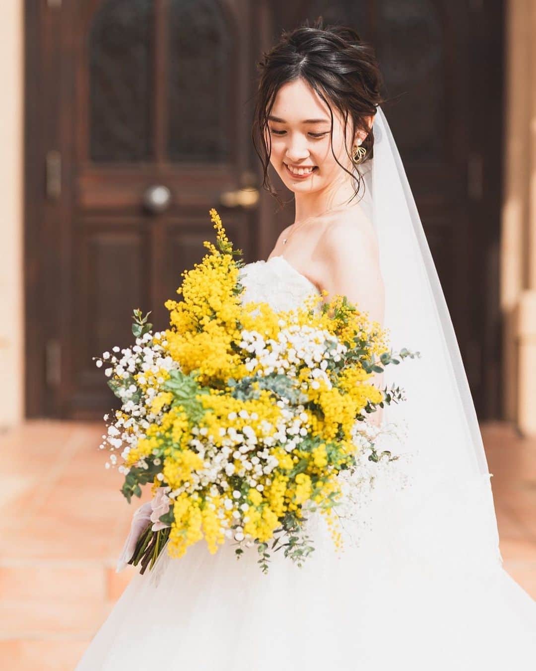 ヴィラデマリアージュさいたまのインスタグラム：「南フランス結婚式の街﻿ ﻿ 女性へ感謝を伝えるための花であるミモザ﻿ ﻿ その鮮やかな黄色い花の色は太陽をイメージさせ、﻿ 厳しい冬の寒さに耐えてきた人々の心を明るく照らす「冬の太陽」としても親しまれてきました﻿ ﻿ しなやかな女性の象徴でもあるミモザは﻿ ご新婦様にぴったりでした﻿ 　﻿ ﻿ ブライダルフェアのご予約は﻿ InstagramのDM・プロフィール欄URLヴィラデマリアージュの公式ホームページにて﻿ ﻿ ﻿ #villasdesmariages#ヴィラデマリアージュ#ヴィラデマリアージュさいたま#結婚式レポート#結婚式場#ウェディング#wedding#ブライダルフェア ﻿ #式場見学#大宮結婚式場#結婚式場探し#式場探し#南フランス#コンセプトウェディング#ガーデンウェディング#プレ花嫁#プレ花嫁準備#プレ花嫁さんと繋がりたい#卒花嫁#卒花嫁レポ#卒花嫁さんと繋がりたい#さいたま#さいたま結婚式場」