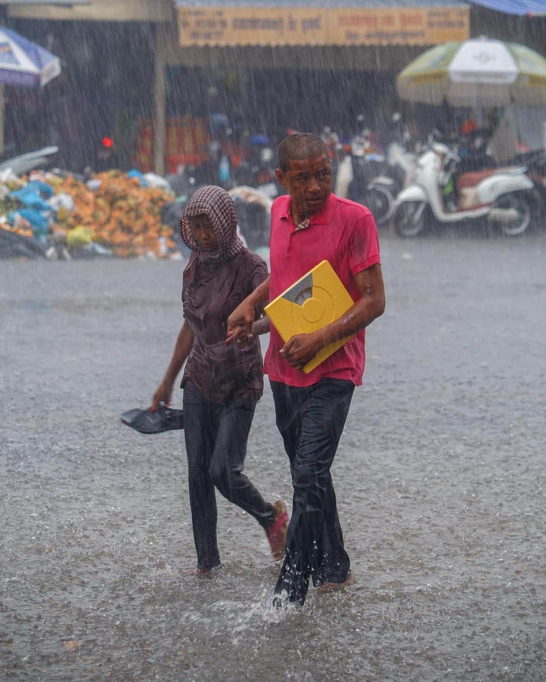 Shunsuke Miyatakeのインスタグラム：「People who are forced to work with scales in the pouring rain, Phnom Penh, Cambodia」