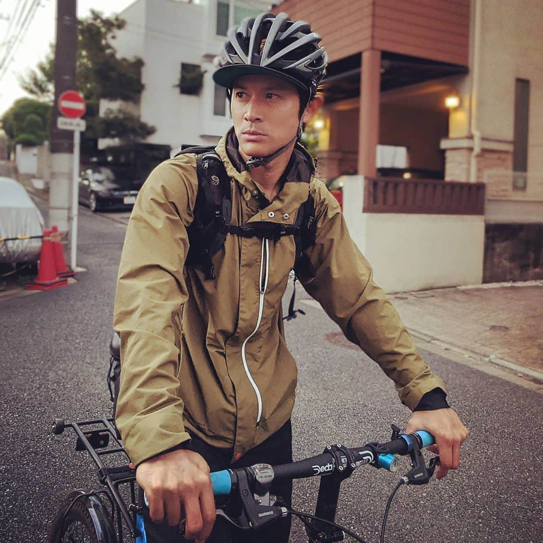 山下晃和のインスタグラム：「【FASHION】le coq sportif Glambike Utility Hoodieはロクヨンクロスのようにシャカシャカで軽量なのにも関わらず、高い防風性、超撥水。  防水も大事だけど、自転車に乗っているときは中が濡れなくて表面ペッタリよりも、パラパラッと水が落ちていくほうがありがたいときも  特にほんの少しの移動とか  ポケットがいっぱいついていてワイヤレスイヤホンとか、交通系決済カードとか、財布とか、スマホとか、目薬とか、マスクとかとか、バッグなしでも生活できてしまうところも便利  @lecoqsportif_japan #自転車ウェア #自転車ファッション #ファッション #FASHION #自転車 #BICYCLE #TOURING #ツーリング #ルコック #ルコックスポルティフ #マウンテンパーカ #mountain  #OUTDOOR #アウトドアファッション #birdy #birdybikes #jitensha #helmet #撥水 #はっ水 #jetpilot #ジェットパイロット #forest #cyclefashion #自転車通勤 #bike #bikeandcamp #バイクアンドキャンプ」