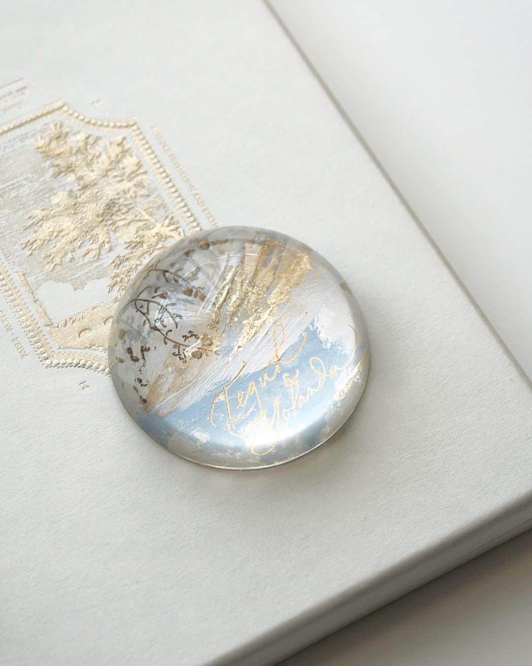 のインスタグラム：「Personalized paperweight to match the wedding stationery theme. Capturing the winter landscape and the glistening snow in the morning light.  — #truffypi #paperweight #domeproject #glasspaperweight #personalizedgift #handpainted #painting #madetoorder #mixmedia  #calligraphystyling #tabletop #stationery #カリグラフィースタイリング  #artobject #waterdrop #bespokestationery #bespokegift #personalizedgift #monogram #calligraphylifestyle #artisanmade #weddinginvitation #styledshoot #weddingstationery #weddingkeepsake」
