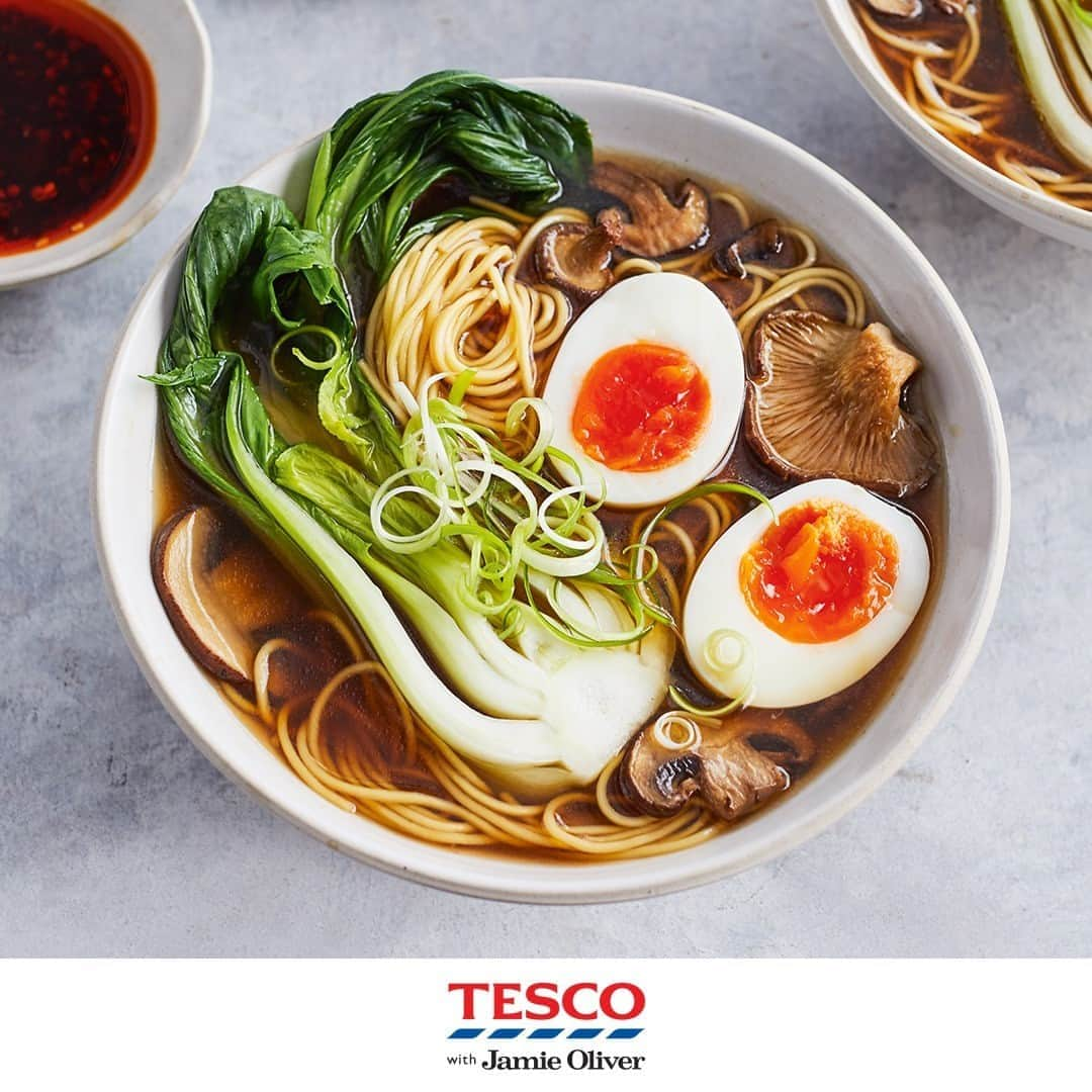 Tesco Food Officialさんのインスタグラム写真 - (Tesco Food OfficialInstagram)「Turn your head right and it’s one face, turn your head left and it’s another… @JamieOliver’s mushroom ramen is packed full of veg, flavour and surprises!  #TescoAndJamie #EatMoreVeg   Ingredients  400g mushrooms 6cm piece of ginger bunch of spring onions 4 garlic cloves olive oil 2 tbsp reduced-salt soy sauce 1.5ltrs organic vegetable stock 4 large free-range eggs 300g fine egg noodles 2 pak choi sesame seeds (optional) chilli sauce (optional)  Method  1. Preheat the oven to gas 4, 180°C, fan 160°C. Finely slice the mushrooms and place in a large roasting tray. Peel and finely slice the ginger, trim and slice the spring onions, reserving the green tops, and peel and bash the whole garlic cloves. Add everything to the roasting tray, mix with 1 tbsp olive oil and a pinch of salt and pepper. Roast for 30 mins or until gnarly.  2. Remove the tray from the oven, add the soy sauce and pour over 200ml of the hot stock, scraping all the sticky bits up from the bottom of the tray. Transfer everything to a large saucepan with the remaining stock and simmer on a low heat.  3. Meanwhile, boil the eggs in a large pan of boiling water for 6 mins. Remove the eggs using a slotted spoon and cool slightly under running water. Peel the eggs and cut in half. Cook the noodles in the egg water to pack instructions, then remove to serving bowls with tongs. Blanch the pak choi for 1 min in the noodle water, drain and slice in half lengthways.  4. Add 2 egg halves and half a pak choi to each bowl. Ladle over the broth. Scatter over the reserved spring onion tops, and sesame seeds and chilli sauce, if you like.」10月14日 1時00分 - tescofood