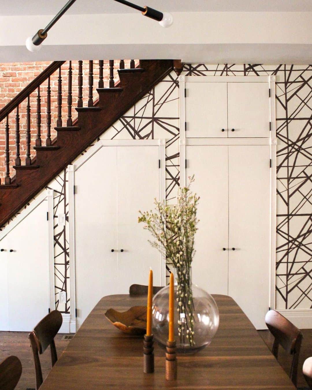Grace Bonneyのインスタグラム：「A Bronx Tale.⠀ _____⠀ Tucked away in a historically rich section of the Bronx, this townhouse took on the services of Casa Marcelo for its cosmetic face lift. After calling this home for several years, the clients felt the space was not reflective of their family’s personality. With this goal in mind, we decorated just enough to infuse their space with Mid-Century elements, dramatic moments, deep-rooted culture, striking artwork, and family values. ⠀ ⠀ We decided to add wallpaper to the wall of closets beneath the staircase, and to change the hardware on the doors to oil-rubbed bronze. After sampling a few wallpapers, we finally decided on @kellywearstler @shopkwearstler Channels Wallpaper in Plum/Oat.⠀ ⠀ Upstairs, in the Master Suite, we outfitted an existing Master Bed with high/low wall sconces, substantial nightstands with USB ports, and finished up the space with a built-in custom bookcase and closet.⠀ ⠀ Finally, in an unused Kids’ Playroom/Guest Bedroom, we completely revamped the space by first adding @florcarpet tiles in a striped, fun pattern, updating a nook beside a brick wall to a workspace for the kids, and by finishing it off with a new media cabinet and pillows for the existing daybed.⠀ ⠀ Click the story to see Before & After Photos from @casamarcelo.co!」
