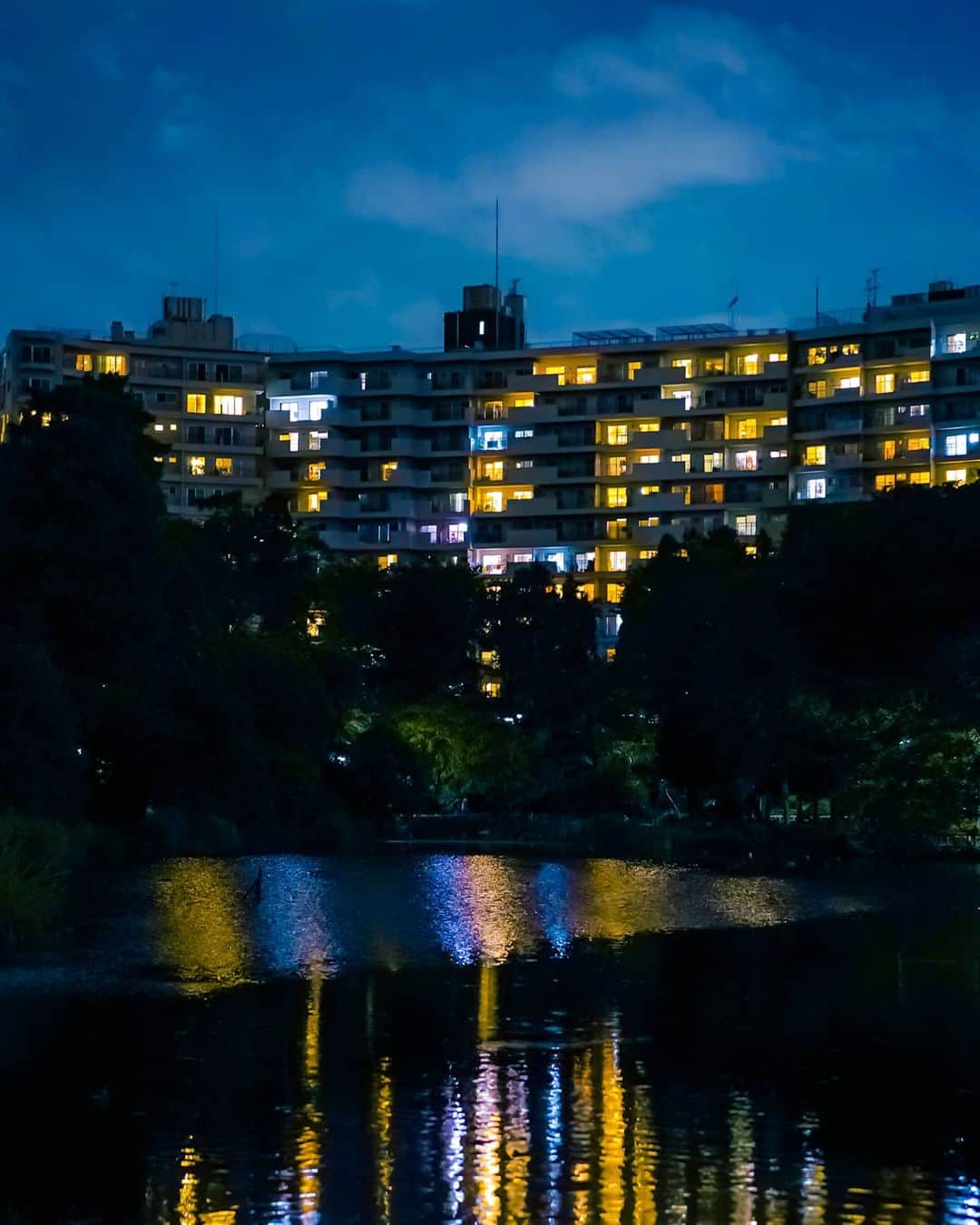 6151のインスタグラム：「それぞれの夜｜窓の数だけある物語を想いながら。  三脚はなかったので手すりに固定しつつ半手持ちで。蒸し暑い夜だった。  このカメラはボディ内手ぶれ補正と高感度耐性が秀逸。 ---  SONYフルサイズミラーレス一眼 「α7C」で撮影した写真とコラムを公式サイトにて掲載中です。  SONY α Universe スペシャルコンテンツ 「NEWgeneration」 https://www.sony.jp/ichigan/a-universe/special_newgen/32.html」