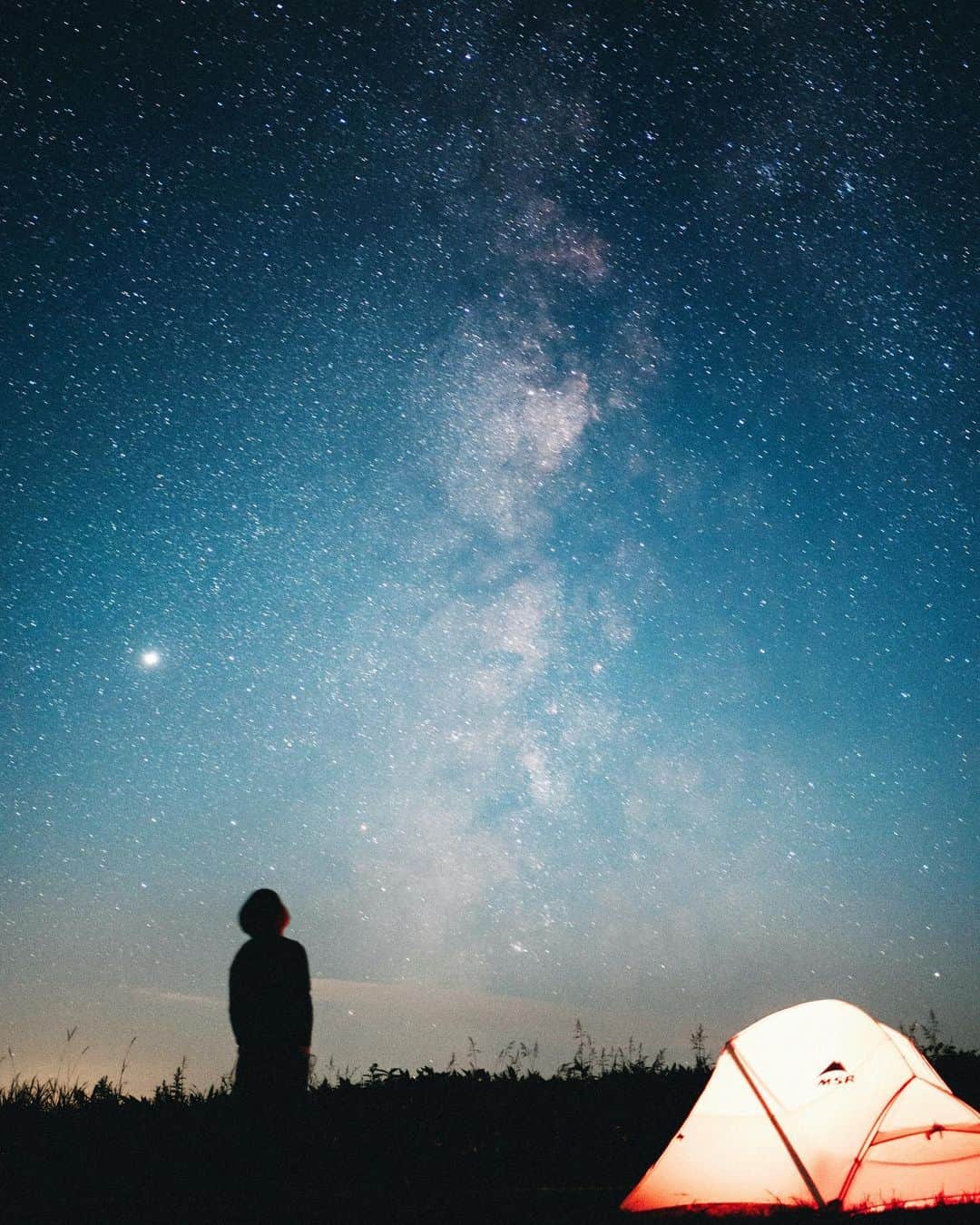 GENTAのインスタグラム：「The night when shooting stars are noisy and I can't sleep💫 北海道の星空はレベルが違います。 その中でもとくに凄いのが中標津の開陽台。 ここはキャンプ場ではないんですが、昔からバイクや自転車で来て勝手にテントを張る人達が絶えなかったため、敷地の一部を無料でテント泊用に開放してくれているありがたい場所です。 標高たった270ｍの丘ですが、周囲は見渡す限りの牧草地帯と地平線。 開陽台のキャッチフレーズは「地球が丸く見える」「視界330°の地平線」。  流れ星がうるさくて眠れないという体験をしたのは、ここが初めてでした。  中標津町のハッシュタグ→ #とことこ中標津  ↓撮ったのはFE35mm F1.8です。 #SEL35F18F #a7RIII #SonyAlpha #BeAlpha」