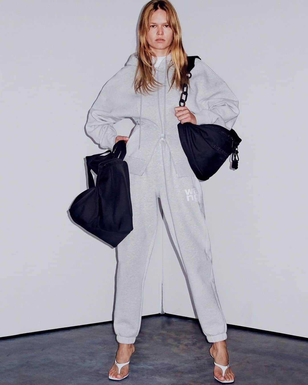 アレキサンダー・ワンのインスタグラム：「A sculpted hoodie for your every move. -  SCULPTED ZIP UP HOODIE IN HEAVY TERRY WITH KANGAROO POCKETS, NIPPED WAIST AND BLOUSON DETAIL AT BACK.  HEAVY BRUSHED FOUNDATION TERRY SWEATPANTS WITH PUFF PAINT LOGO ON LEFT UPPER THIGH.  PRIMAL NYLON LARGE TOTE WITH TONAL LOGO EMBROIDERY.  ATTICA NYLON GYM FANNY PACK WITH ACRYLIC CHAIN AND TONAL LOGO EMBROIDERY.  IVY THONG SANDAL WITH DIAMANTÉ LOGO HARDWARE.  SOFT SERVE SHOT TO SHOP BY STEVEN KLEIN.」