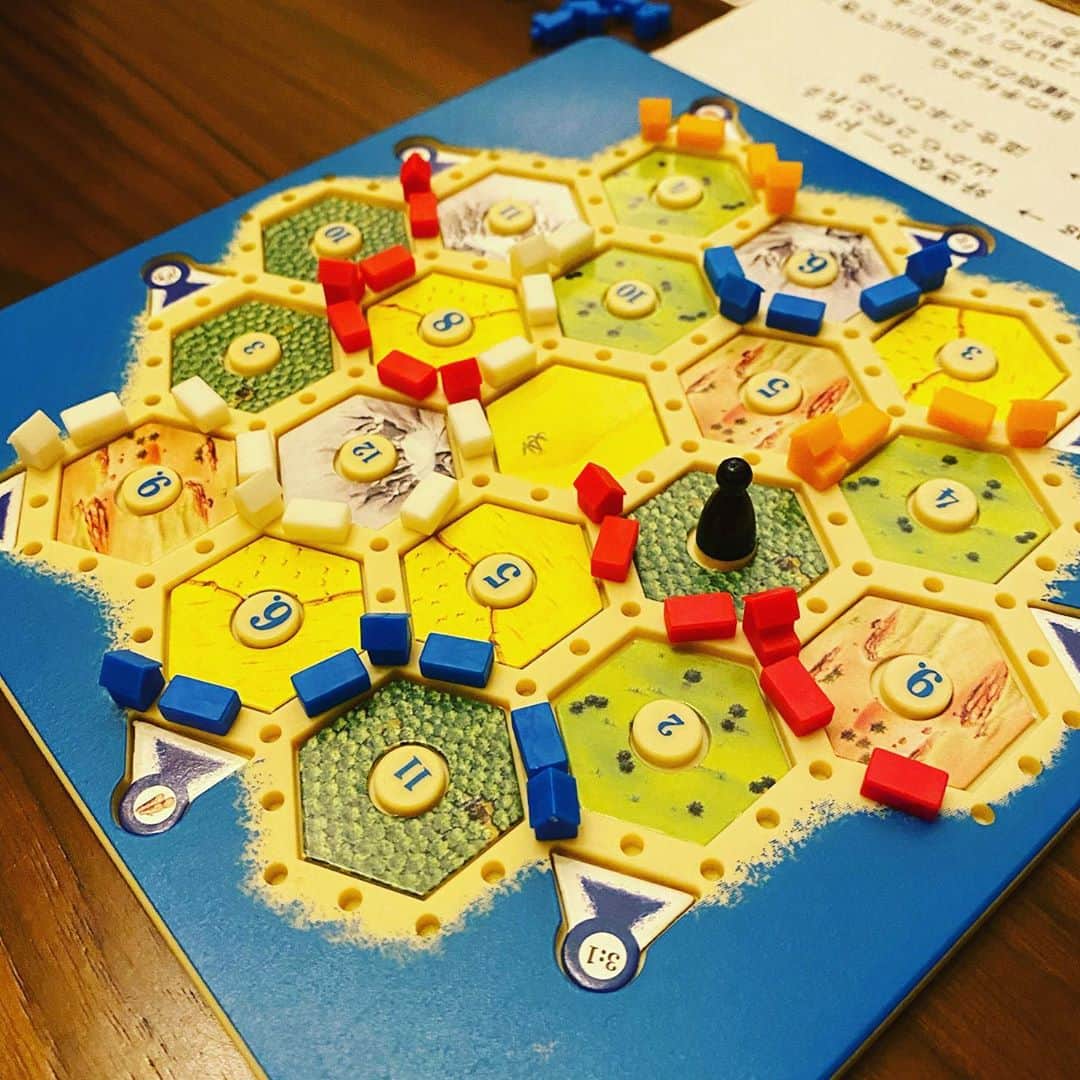 Taku Takahashiのインスタグラム：「カタン  今まで色々なボードゲームをやってきたけど、やっぱりいちばん面白いのはこれ。『カタン』という島に道と家と工場を建てて開拓していくゲーム。  家は1点、工場は2点、最初に10点取った人が勝ち。建てていくには資源カードが必要。木、土、麦、牧場、鉄のカードのコンビネーションで作っていく。  このゲームの楽しさは資源カードをそれぞれのプレーヤーと交換ができるところ。例えば「鉄を差し上げます、誰か木と交換してもらえませんか？」と聞いて「うーん、今、木はあまり出てないから鉄2枚となら交換してもいいですよ」ってな感じで交渉をしていく。  交渉の仕方でプレーヤーそれぞれの性格も出るし、さまざまな駆け引きやぶつかり合いでドラマがうまれる。上がりそうな人を残りのプレーヤー達で阻止することもできるのも醍醐味。真面目そうに見えて、意外と笑いが多くうまれる。  スマホや電子ゲームも楽しいけど、こういうボードゲームは会話しながらできるから好き。」