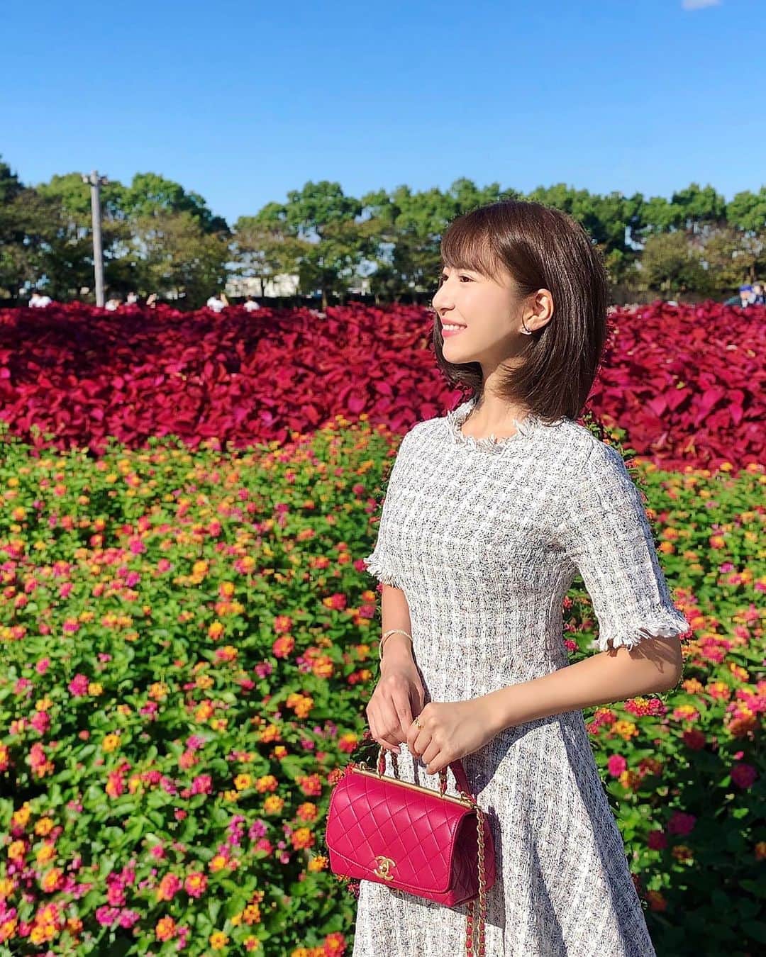 のインスタグラム：「🍂🍁🧡 秋晴れで太陽がまぶしい🌞 . こんばんは😊 昨日の投稿の別カットです💕 . お天気が良く日向は目を開けられないくらい 眩しくて、唯一撮れた一枚がこちら💁🏻‍♀️ . . 赤いポインセチアと橙のコスモスの コントラストが綺麗な場所💓 . . 沢山ご質問いただいたツイードのワンピースは @re0g1na さんのです❤︎ . Onepiece：#regina #pr Bag：#chanel #シャネル . #なばなの里 #コスモス畑 #秋桜 #ナガシマスパーランド #nabananosato #nagashima #コスモス #花畑 #赤リップ #きれいめコーデ #大人コーデ #秋コーデ #ホワイトコーデ #ツイード #お出かけコーデ #管理栄養士 #秋空 #秋風 #夕暮れ #夕暮れ時」