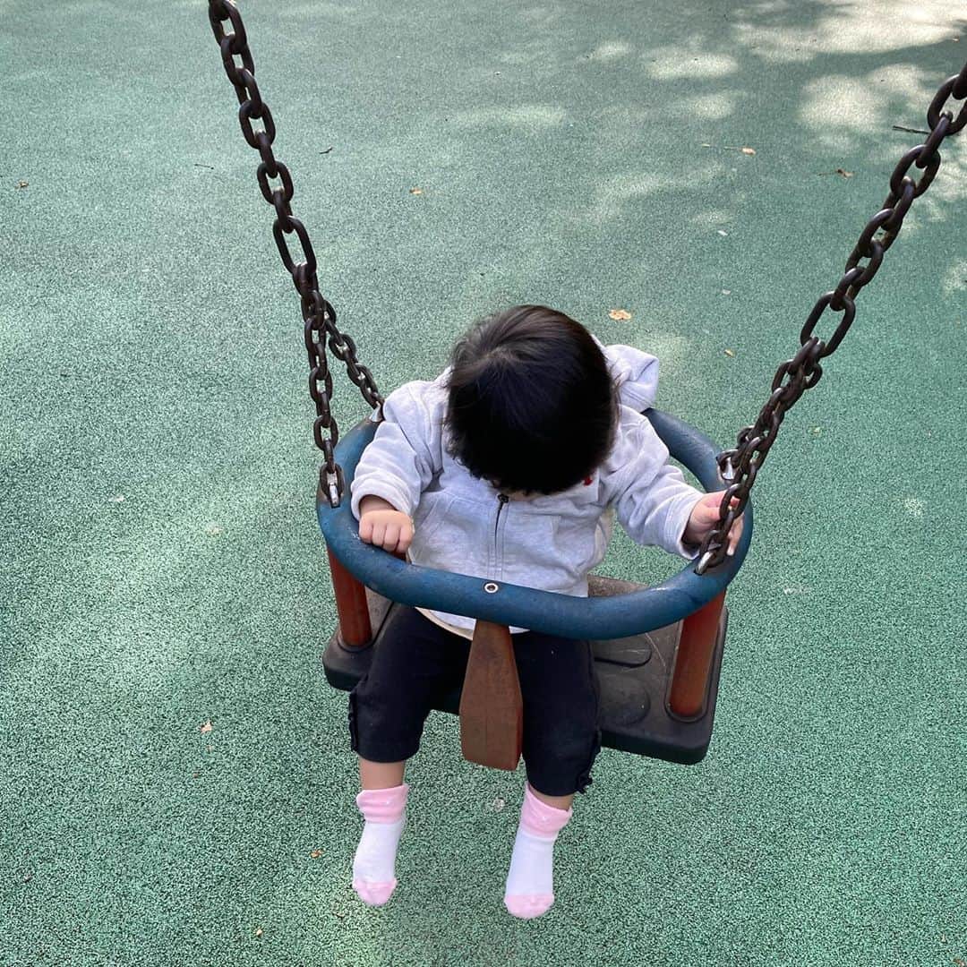 岡村仁美のインスタグラム：「ロンドンで見かけるブランコ。バーに脚を通すこういう形のものが多いです。  抱っこして一緒に乗れないので、ようやくデビューさせてみました。  なぜか地面ばかり見つめる長女。  ブランコに乗せるのも順番に一人ずつ👶👶  ロンドンはすっかり寒くなり、公園にも長時間はいられなくなりました🍂  #ブランコデビュー #ロンドン生活 #双子育児 #生後9ヶ月」