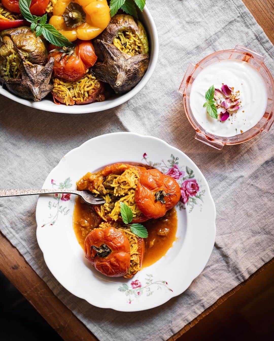 Saghar Setarehさんのインスタグラム写真 - (Saghar SetarehInstagram)「A study of #Dolmeh in Persian/ #Dolma in Turikish/ Mahshi in Arabic /Gemista in Greek  It started with a desire to recreate my mom’s dolmeh; stuffed aubergines, tomatoes and bell peppers. (Any vegetable stuffed with other ingredients is Dolmeh: vine leaves, cabbage leaves, little zucchinis, onions, even apples and quince). I distinctly remembered tiny dices of meat (NOT minced), a little bit of chana dal in an aromatic rice, inside the belly of pretty round aubergines, juicy tomatoes and colorful bell peppers.  However when I looked for the recipes in my Iranian cookbooks, I came upon different recipes, and when I asked Iranian friends, even more different varieties emerged. I had always known that these stuffed vegetables have different recipes in different countries of the Middle East, the Mediterrean, Central Asia and the Balkan area, but I didn’t expect quite so many varieties to emerge from just a simple query on Twitter among Iranian foodies.   One thing that I have noticed though, it looks like the more West these stuffed vegetables travel, the simpler they become. According to my friend @thefoodiecorner, in her cookbook Gemista the Greek stuffed tomatoes and peppers shouldn’t have meat in them (although there’s always a debate on that among the Greeks), just rice and herbs. And by the time you get to Rome, the tomatoes are stuffed with rice alone.   The Iranian versions I’ve read about so far, always have herbs in them. But the mixture varies sometimes. My mom’s and @bottomofthepot's mom version don't have any herbs. So that’s how I cooked these. Some of the other versions of Jewish Iranians according to @tannazsassooni even have dry fruits in them.   All of this and I haven’t even looked into what happens in Eastern Europe and Central Asia. @oliahercules for one, has a stunning stuffed pepper recipe in her latest cookbook Summer Kitchens, and it’s yet different from all these other version.  Someone with a meticulous research and dash of mania could write a cookbook ONLY on dolmeh recipes in different regions.  I’m taking these babies to a picnic on the beach tomorrow. Meeting friends outdoors. The only reasonable way, these days.」10月18日 0時08分 - labnoon