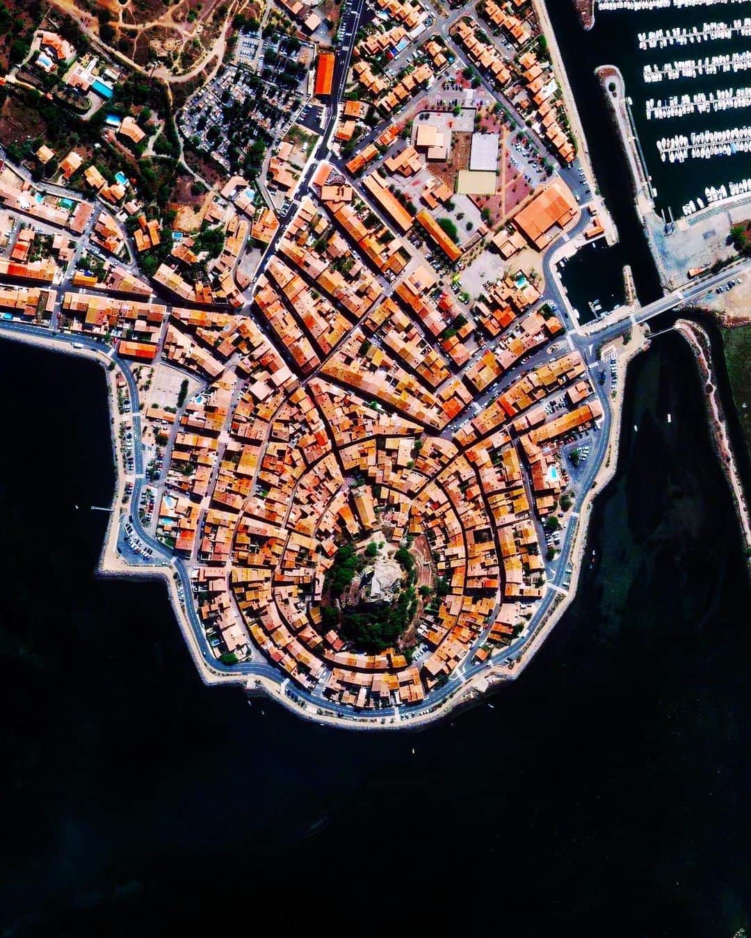 Daily Overviewさんのインスタグラム写真 - (Daily OverviewInstagram)「Gruissan is a commune of about 5,000 residents, located on the Mediterranean coast of southern France. Traditionally a fishing village, the circular town is built around a former 10th century château, of which only the Tour Barberousse (Redbeard Tower) remains. The castle ruin can be seen near the center of this Overview surrounded by green trees. - Created by @overview, source imagery: @maxartechnologies」10月18日 5時31分 - dailyoverview