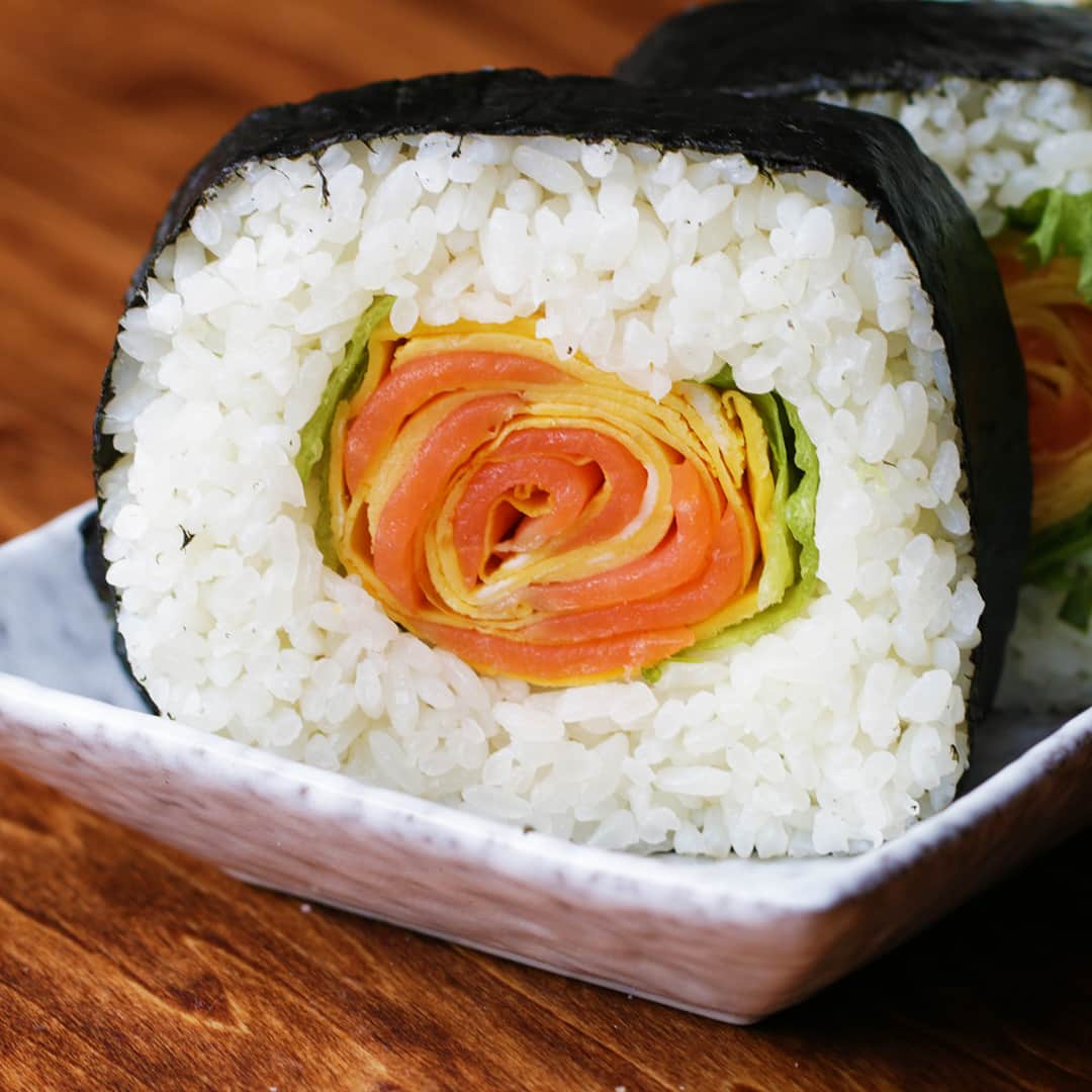 Tasty Japanさんのインスタグラム写真 - (Tasty JapanInstagram)「薔薇の飾り巻き寿司🍣🌹〜牛乳パックで簡単〜 / Salmon Roll⁣ ㅤㅤㅤㅤㅤㅤㅤㅤㅤㅤㅤㅤㅤ⁣ 作ったら #tastyjapan をつけて投稿してくださいね！✨⁣ ㅤㅤㅤㅤㅤㅤㅤㅤㅤㅤㅤㅤㅤ⁣ レシピはこちらをご覧ください♪⁣ ㅤㅤㅤㅤㅤㅤㅤㅤㅤㅤㅤㅤㅤ⁣ 薔薇の飾り巻き寿司⁣ 4人分⁣ ㅤㅤㅤㅤㅤㅤㅤㅤㅤㅤㅤㅤㅤ⁣ 材料：⁣ 温かいごはん 500g⁣ ■すし酢⁣ 米酢 大さじ3⁣ 砂糖 大さじ2⁣ 塩 小さじ1⁣ ㅤㅤㅤㅤㅤㅤㅤㅤㅤㅤㅤㅤㅤ⁣ ■薔薇　⁣ 薄焼き卵 4枚⁣ スモークサーモン 80g⁣ フリルレタス 4~5枚⁣ 焼きのり 2枚⁣ ㅤㅤㅤㅤㅤㅤㅤㅤㅤㅤㅤㅤㅤ⁣ 作り方：⁣ 1.牛乳パックは側面(1面)と上部を切り、パウンド型になるようにテープでとめておく。⁣ ㅤㅤㅤㅤㅤㅤㅤㅤㅤㅤㅤㅤㅤ⁣ 2.ボウルに米酢、砂糖、塩を入れ、砂糖が溶けるまで混ぜる。⁣ ㅤㅤㅤㅤㅤㅤㅤㅤㅤㅤㅤㅤㅤ⁣ 3.温かいごはんに(2)を回し入れ、しゃもじで切るように混ぜる。⁣ ㅤㅤㅤㅤㅤㅤㅤㅤㅤㅤㅤㅤㅤ⁣ 4.薄焼き卵を少し重なるように縦に並べ、その上にスモークサーモンを感覚をあけて並べ、端から巻いていく。⁣ ㅤㅤㅤㅤㅤㅤㅤㅤㅤㅤㅤㅤㅤ⁣ 5.紙パックの底と側面に、しゃもじで酢飯を詰める。⁣ ㅤㅤㅤㅤㅤㅤㅤㅤㅤㅤㅤㅤㅤ⁣ 6.中央にフリルレタスを敷き、(4)をのせ、さらにフリルレタスをのせる。⁣ ㅤㅤㅤㅤㅤㅤㅤㅤㅤㅤㅤㅤㅤ⁣ 7.残りの酢飯を詰めて、表面が平らになるように形を整える。形が整ったら逆さにして紙パックから酢飯を取り出す。（出てこない場合は紙パックに切り込みを入れて剥がしてください。）⁣ ㅤㅤㅤㅤㅤㅤㅤㅤㅤㅤㅤㅤㅤ⁣ 8.海苔を2枚少し重なるように縦に並べ、手前に(7)をのせ、全体を巻く。ラップに包み、海苔が馴染むまで少し置く。⁣ ㅤㅤㅤㅤㅤㅤㅤㅤㅤㅤㅤㅤㅤ⁣ 9.好みの厚さに切ったら、完成！⁣ ㅤㅤㅤㅤㅤㅤㅤㅤㅤㅤㅤㅤㅤ⁣ #料理 #手料理 #レシピ #料理動画 #クッキング #美味しい #ランチ #おうちごはん #夜ごはん #TastyJapan #BuzzFeed #cooking #Tasty #Japan #dinner #lunch #homemade #cook #delicious #お寿司 #food #sushi #グルメ #食べ物 #recipe #飾り寿司 #レシピ動画 #寿司 #巻き寿司」10月18日 17時01分 - tastyjapan