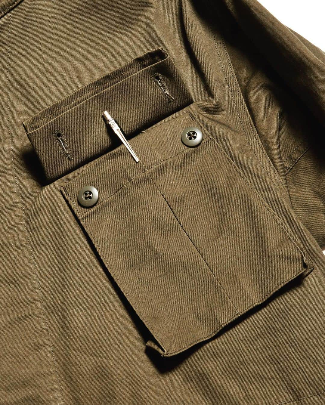 サウンドマンさんのインスタグラム写真 - (サウンドマンInstagram)「Soundman '20AW Collection  ITEM. "Nowwood "(ノーウッド）・ 713M-961Q・Army Green C/#47  US ARMYのジャングルファティーグJKとBritish ARMYのヘリクルーパーカーを融合させたイメージのミリタリーJK。	 ジャングルファティーグJKの特徴であるボックスプリーツ入りの4つのフロントポケットを配した身頃と	腕の上げ下げがし易く可動域が広いヘリクルーパーカーの袖仕様（ピヴォットスリーブ）を合わせた。  また釦にて脱着可能のフードを	外すことによりスタンドカラーJKの見え方をする。  表地にははムラ糸入りで毛羽立ちが少ない中肉のヴィンテージライクなコットンドリルを使用。  20SS好評を博した型に暖かみのあるコットンネルの裏地を付けた秋冬ver.  #soundman #soundman.jp #サウンドマン #2020aw #mensfashion #heritagestyle  #heritagemenswear  #madeinjapan  #usarmy #britisharmy  #military  #vintagestyle #少量生産 #junglefatigue」10月19日 12時19分 - soundman.jp