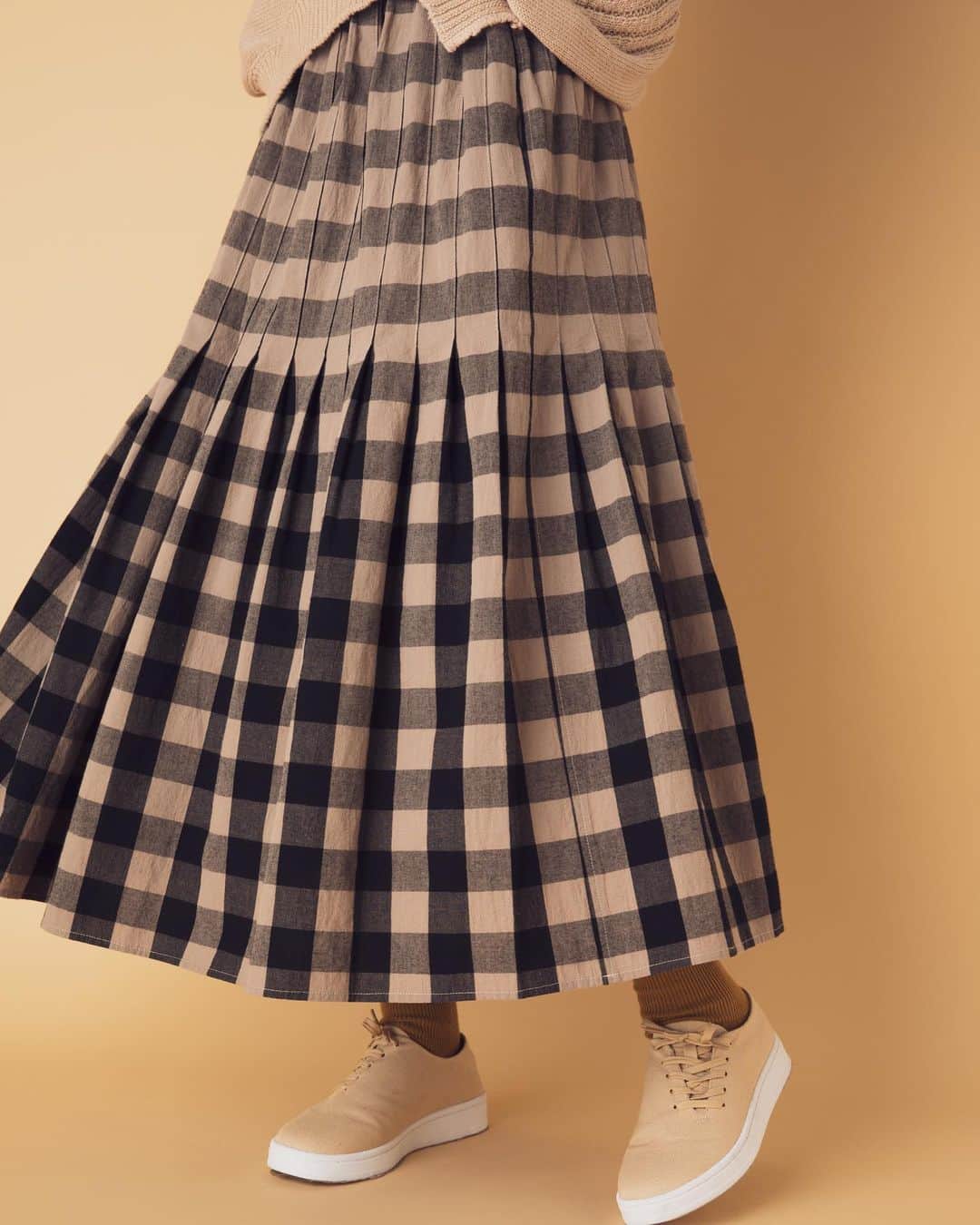 ネ・ネットのインスタグラム：「■GINGHAM TUCK﻿ ﻿ 表面に細かいシボ感のある独特な風合いを出した着心地のいい綿素材でつくったビッグギンガム柄のスカート。長方形の1枚の布にタックを入れて構成されたデザインは、ギンガムチェックの生地の柄に合わせてたたむことで、ウエスト部分の柄はボーダー柄に変化しています。 ウエストはゴム仕様でストレスフリーな軽い着心地ながらも、タックをたたむことで腰回りがすっきりみえるのもうれしいポイント。﻿ ﻿ #ネネット #nenet #新作 #new #autumn #winter #2020 #collection #fashion #tokyo #gingham #tuck #ギンガム #ギンガムチェック」