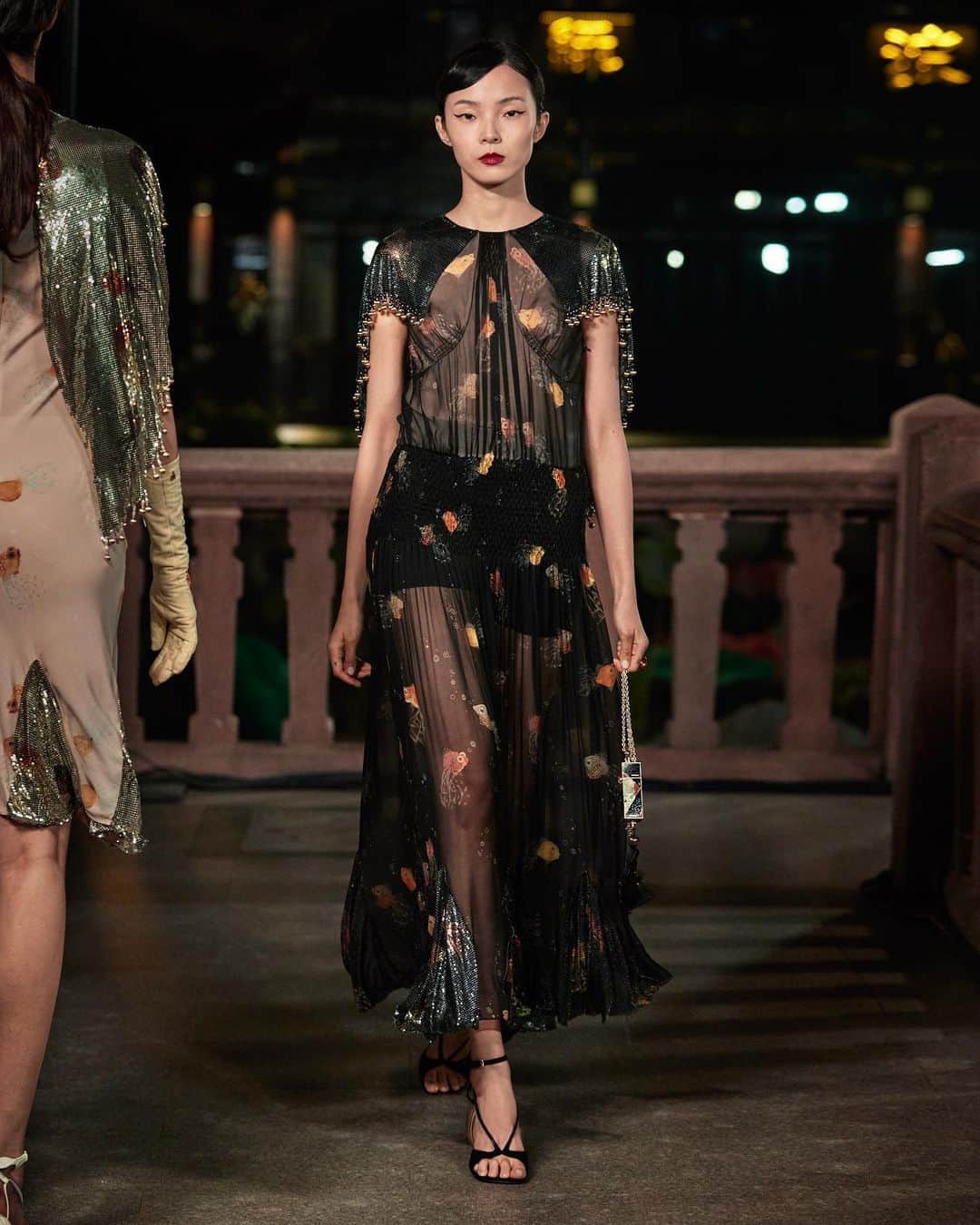 ランバンのインスタグラム：「The context of the Spring/Summer 2021 show by @brunosialelli inspires: the influence of Chinese culture on the art and fashion of the 1920s was fundamental. The two-dimensional, stylised aesthetic of Chinese art influenced Art Deco's linear style, streamlined silhouettes, focus on decoration. In a constant cultural exchange, reference dart between China and France, fusing the two in a simultaneous celebration of both cultures and their shared cherishing of the luxurious, the limited, the unique. Silhouettes and fabrics are sensual, draped against the body for him and her. Women’s dresses drape gently across the body, sometimes weighted with chain-mail, another archival nod to Jeanne Lanvin’s limitless innovation. Designs again reference Wen goldfish, embroidered or woven in fils-coupe silk-velvet. Gold is a key color: an entire spectrum, from palest blonde, to rose, to ocher and gilded metallics of lamé and leather. #LanvinYUGARDEN #Shanghaifashionweek」