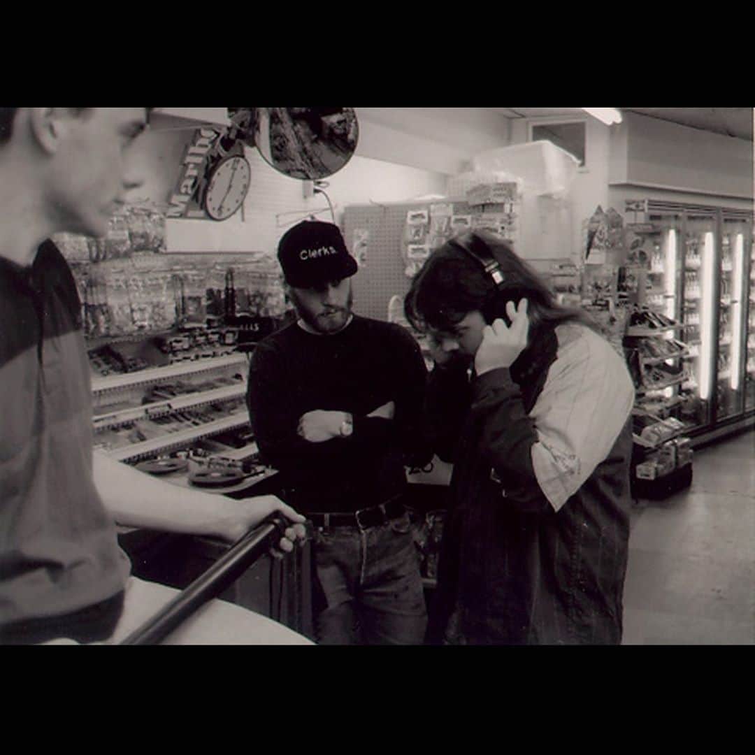 ケヴィン・スミスのインスタグラム：「26 years ago from now, I was headed to the @angelikafilmcenterny to see the first film I ever directed in an actual theater with other real, live paying customers! CLERKS opened on 2 screens in the USA: 1 in N.Y.C. and 1 in L.A. The flick would never play on more than 50 screens at its widest, but even still, a l’il black & white movie from New Jersey made a dent in the universe. In this pic, I’m listening to dialogue playback as Scott and Vincent wait for a verdict. This photo was taken 27 years ago but I still remember when Ed Hapstak took it. Thanks to @samosier, @davidkleinasc, @briancohalloran, #jeffanderson, @jaymewes, @marilynghigliotti, #lisaspoonauer, #vincentpereira, @scottschiaffo, @desserttheatre, @quickstopgroceries, @donsgirlgrace, @tellemants, #edhapstak #waltflanagan, #kimloughran, the town of #leonardonj #rajivthapar, #slacker, @virginia_in_vienna, @marktuskflaneurfoto, all the bands on the soundtrack, #bobhawk, #johnpierson, @miramax, and anyone who ever saw (or saw themselves represented in) the flick. Clerks is and will always be the best magic trick I ever performed. It’s the cinematic equivalent of pulling a quarter out of someone’s ear: some barely clever sleight-of-hand that makes the audience think - even for a few seconds - that anything is possible. And that was the true lesson of #clerks for me: if you surround yourself with friends who believe in you and your dopey dreams, anything *is* possible. Happy ClerksDay! We’re not even supposed to be here today! #KevinSmith #film #indie #1994」