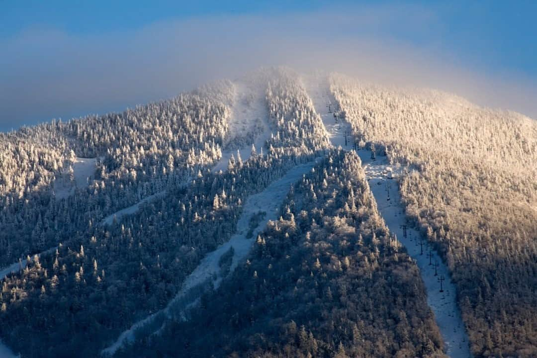 ナショナルジオグラフィックさんのインスタグラム写真 - (ナショナルジオグラフィックInstagram)「Ode to Vermont by @hannahteter / The Green Mountain State attracts people from around the world with its neon colors every fall, and fills their bellies with maple syrup, cheddar cheese, and Ben & Jerry’s. Vermont has the best of both worlds—mountains full of snow and beautiful lakes all around. Growing up on a mountaintop, my mom had a huge organic garden overly abundant with fruits and vegetables; the fertile Vermont soil and perfectly humid summer climate makes living off the land a little easier. This is the birthplace of snowboarding, created here by Jake Burton. Vermont led the charge to a globally loved sport and Olympic dreams for many—including myself.  Photo by @timlaman / Ski lifts make their way up Madonna Mountain at Smugglers’ Notch. The ski resort features 78 ski and snow-boarding runs.  This text and accompanying image are from “America the Beautiful,” a new Nat Geo book, with more than 200 images from all 50 states, highlighting America’s unique natural and cultural treasures. Check out Nat Geo’s link in bio to learn more.」10月20日 19時00分 - natgeo