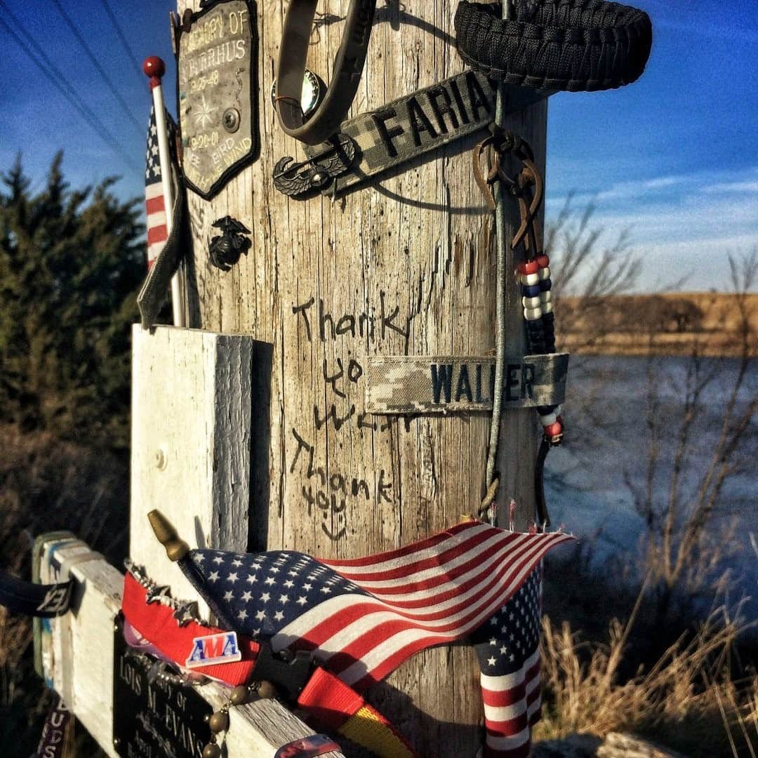 のインスタグラム：「Ode to Iowa by Peggy Whitson @astro_peggy / “To Be of the Earth” was a poem I wrote as a kid. For me those words describe rolling hillsides of corn and soybeans that make up Iowa. Black Angus leisurely grazing the pastures of timothy and clover, calves frolicking beside. A life, and a way of life, that nurtured and supported my dreams.  Photo by David Guttenfelder @dguttenfelder / Flags, military patches, and memorial messages decorate a telephone pole that stands along a county road dedicated to United States military veterans.  This text and accompanying image are from “America the Beautiful,” a new Nat Geo book, with more than 200 images from all 50 states, highlighting America’s unique natural and cultural treasures. Check out Nat Geo’s link in bio to learn more.」