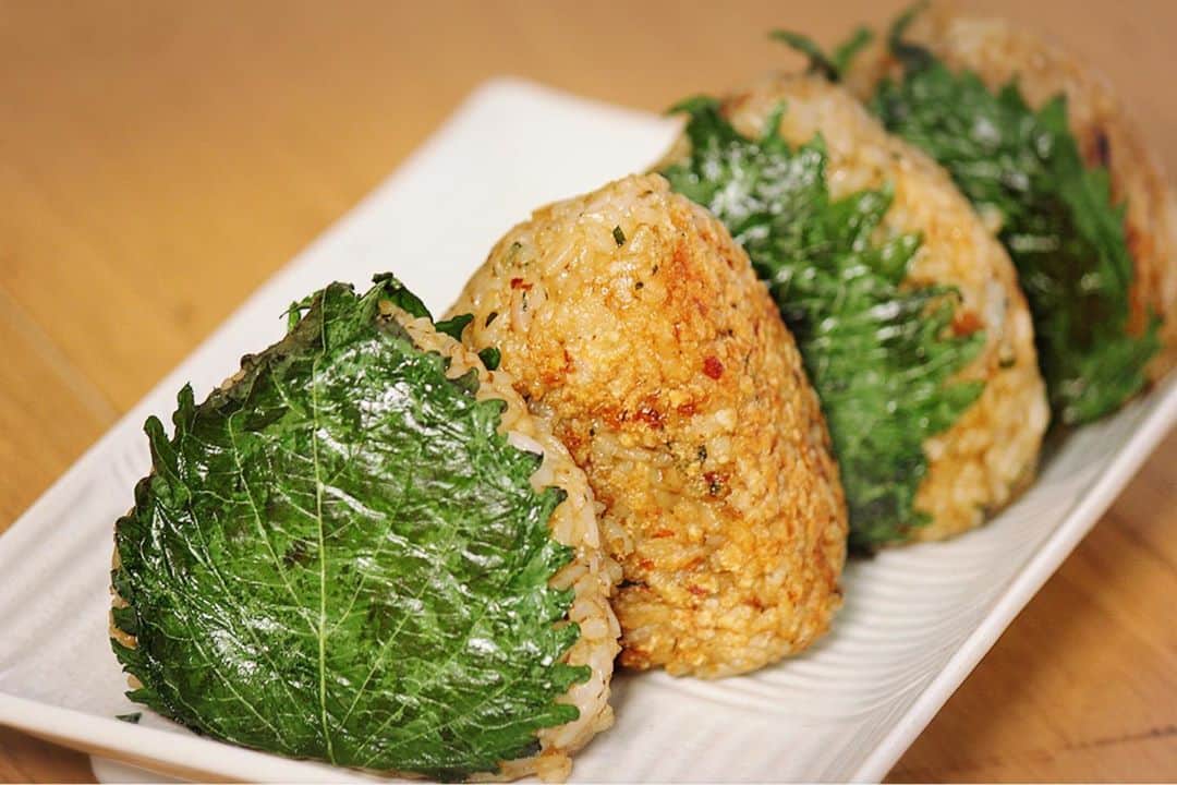 川島章良のインスタグラム：「. . .  今回作ったのは『だし香る焼きおにぎり』です  しそが巻いてあっておかかご飯プラスだしが入っているので、  だしが香りうまみがすごいことになってます。  梅いれたらさらに美味しくなりますよ。  今回はシンプルバージョンです。  材料 ・ご飯 ・カツオ節　2パック ・大葉 11枚 ・醤油 大さじ1 ・だしパック　1パック  作り方はYouTubeのかわだしクッキングを観てください。 お願いします🤲  #かわだしクッキング  #だしパック #だしパック料理研究家  #焼きおにぎり #おにぎり #しそ #おにぎりレシピ」