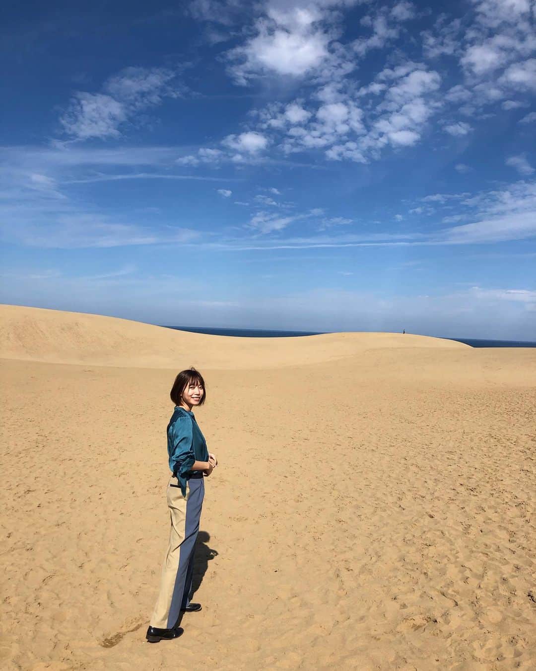 のインスタグラム：「じゃん！辻詩音はいま #山陰海岸ジオパーク さんに呼んで頂き、ジオパークの素敵な場所を紹介する旅任務をさせてもらってます。 今はこういう時期ですが、みんなにGo toとかで行ってみたいなと思ってもらえるようたくさん写真を載せていくので、ぜひ見てくれたら嬉しい！ ここは鳥取砂丘。 渇きを求めて砂漠に出ました🏰 (ここからはわたしの楽曲「砂漠」をBGMにしながら写真をご覧ください。) 生で観る砂丘の圧巻具合すごかったよ。 Twitterにも書きましたが、風で少しずつ毎日形を変えてる砂丘、自然のエンタメすごいね。 平日の早めだったからか、人も少なめでこういう写真が撮れました。 なにこれ普通にジャケ写！ (※撮影時以外はマスクを着用しています)  #鳥取砂丘 #わおじお #山陰海岸ジオパーク #鳥取旅行 #鳥取 #地質公園 #ジオパーク　#砂漠 #辻詩音 #japantravel #japantrip #辻さんぽ」
