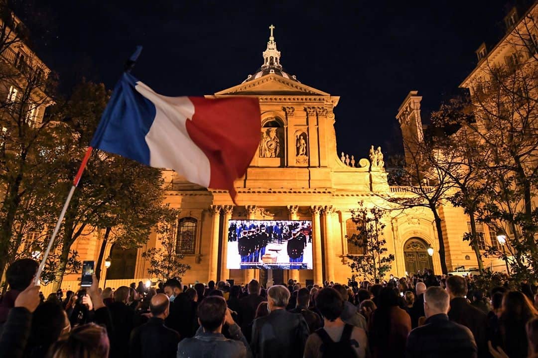 AFP通信さんのインスタグラム写真 - (AFP通信Instagram)「AFP Photo 📷 Bertrand Guay - An attendee waves a French flag as people gather on the Place de la Sorbonne in Paris on October 21, 2020, to watch a live broadcast on a giant screen of a national homage at the Sorbonne University to French teacher Samuel Paty, who was beheaded for showing cartoons of the Prophet Mohamed in his civics class.⁣ .⁣ France pays tribute on October 21 to a history teacher beheaded for showing cartoons of the Prophet Mohamed in a lesson on free speech, an attack that has shocked the country and prompted a government crackdown on radical Islam. Seven people, including two schoolchildren, will appear before an anti-terror judge for a decision on criminal charges over the killing of the 47-year-old history teacher. #samuelpaty」10月22日 17時55分 - afpphoto