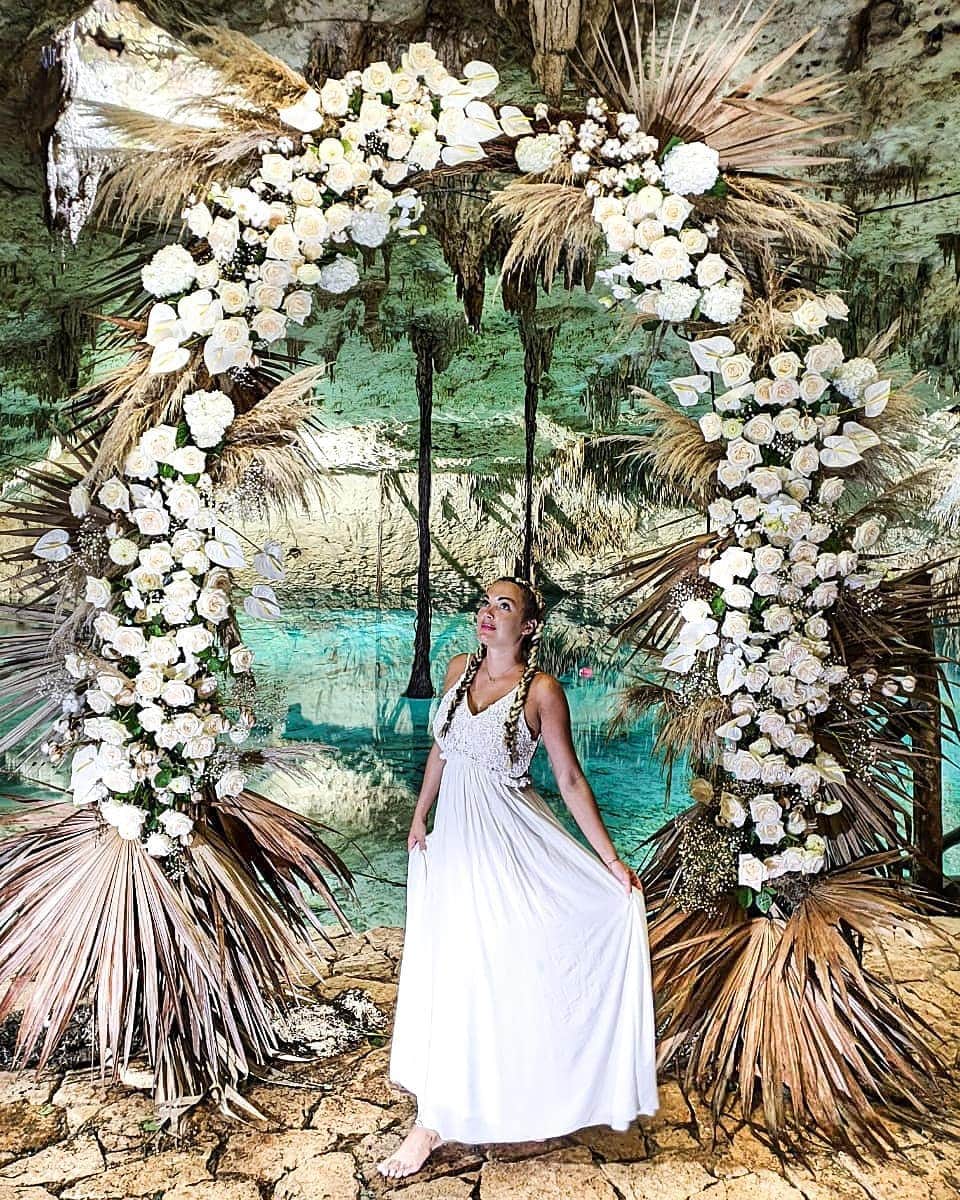 アリサ・ラモスのインスタグラム：「I got married!!! ...to myself...in the Mayan underworld...🤪 👰🏼‍♀️ . Jk but huge shout out to whoever did get married in this gorgeous, secret Cenote near Tulum for the epic idea, annnnddd for leaving this massive real flower archway! And I guess me for randomly wearing a long white dress to it. . Also big shout out to my friends Vanessa and Oliver from @turismochannel for not only showing me this lesser known Cenote in an actual little Mayan village, but for taking so many incredible photos and videos for me! I was seriously blown away by their determination to get their guests photos!! . That being said, if you want alllll the token photos, and unique photos, plus  a fun, safe, tour of Tulum, I HIGHLY recommend them! (Seriously tho, I saw two other private tours in here and the guides weren't taking any pics!!). . Now back to "my wedding"...I've already been to the top honeymoon destinations by myself (French Polynesia, Maldives, Santorini, Zanzibar, Seychelles), but for my actual wedding I want ceremonies in super unique, rare places (and yes I want multiple ceremonies haha).  . Where do you think I'd surprise everyone with an epic wedding? (Think on the level knowing I celebrated my 30th bday in Antarctica 😜) . Where would you have yours if it could be anywhere in the world (either to yourself or someone haha)?? . . . . #mayanriviera #cenote #mytulum #tulum #mexicancaribbean #wedding #weddingdress #weddinginspiration #MyLifesATravelMovie #alyssaramostravels #tlpicks」