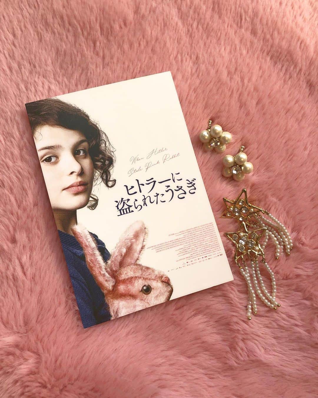 のインスタグラム：「🎬ドイツで大ヒット🇩🇪 『ヒトラーに盗られたうさぎ』試写。 ． ナチス迫害を逃れるため、故郷ドイツを離れ、スイス・フランス・イギリスへと過酷な亡命生活を強いられることになった家族。 9歳の少女アンナは、貧困や差別などの困難を乗り越えながら家族との絆を深めていく…。 ． 世界的絵本作家ジュディス・カーの少女時代の体験を基にした自伝的小説が映画化。 この作品、実話ベースのお話なんですよね。 もう、胸がキューーーっとなる。 9歳の女の子が、祖国から、大好きなお家から離れなくちゃいけない。 お母さんから「ぬいぐるみは一個しか持っていけないから」って言われて、 ぬいぐるみを真っ直ぐに見つめるアンナが愛おしくて。苦しくて。 アンナだけじゃなく家族それぞれの苦悩があって、 それも細々と描かれているのがよかった。 立派なお父さんとお母さん。 お金がなくても、めいっぱいの愛をくれる。 子供がいてもふたりでデートして、 公園のベンチでチョコレートケーキをがぶーっとかぶりついて、そのままキスする。 チョコレートで口周りベッチャベチャよ。笑 それが、良い。 日常のこういうシーン、大好きなんだよね。 そう、私気づいたんだけど、食べ物からのキスシーンが大好きなんだわ😂←急に🤣 『グッド・ウィル・ハンティング』のハンバーガーキスもそうだね、大好きだね🍔👩‍❤️‍💋‍👨 食べ物からのキス。最高。 あー。 話が脱線しだしたのでまたこの話はどこかでします。😂 この作品で描かれていた家族のかたち。 いつか、こんなふうになれるかしらとジーンとしちゃった。 生きる希望を見出して、逞しく生きていく姿。 今を生きる私たちにも大切な、 苦境に負けないコツを教えてもらったような気がする。 ． それでね、 アンナ役のリーヴァ・クリマロフスキちゃんがめーーーっちゃ可愛いのよ😭 1000人のスカウトから見出されたそう。 くちびるがぽってりしてて。 (くちびるだけ見たらほぼアンセル・エルゴート👄w) ファッションもめちゃくちゃ可愛い。。 コーデの組み方全部可愛い。 花柄のワンピースにヴィヴィッドなピンクのカーディガンを合わせたり。 鮮やかな真っ赤なニットにネイビーのハーフパンツに、白ソックス。 映画はファッションのお勉強になります😊 ． 11月27日より公開です。 ぜひ、劇場でご覧ください🐇 ． #ヒトラーに盗られたうさぎ  #ドイツ映画  #映画  #映画好き」